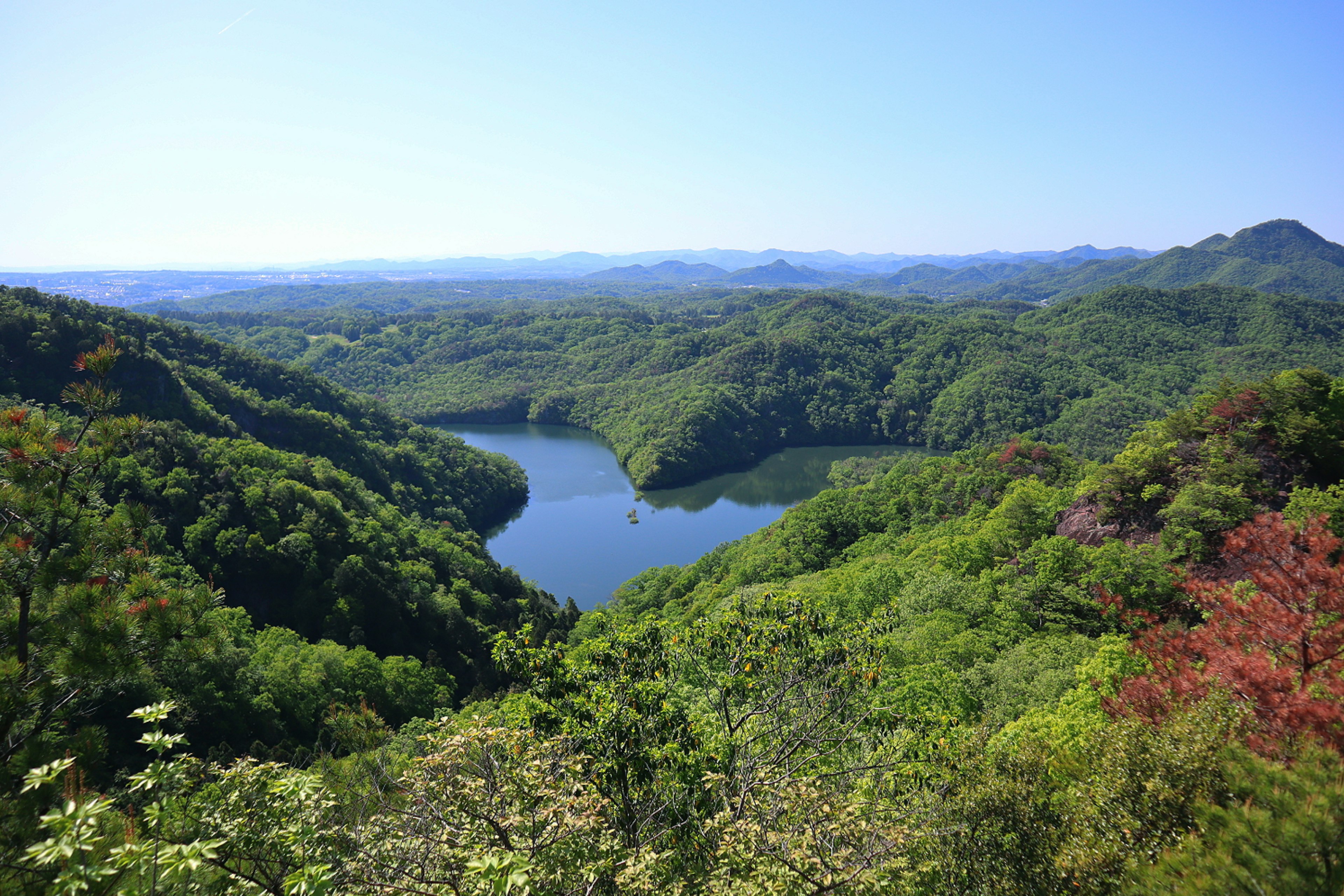 Montañas verdes y un lago bajo un cielo azul claro