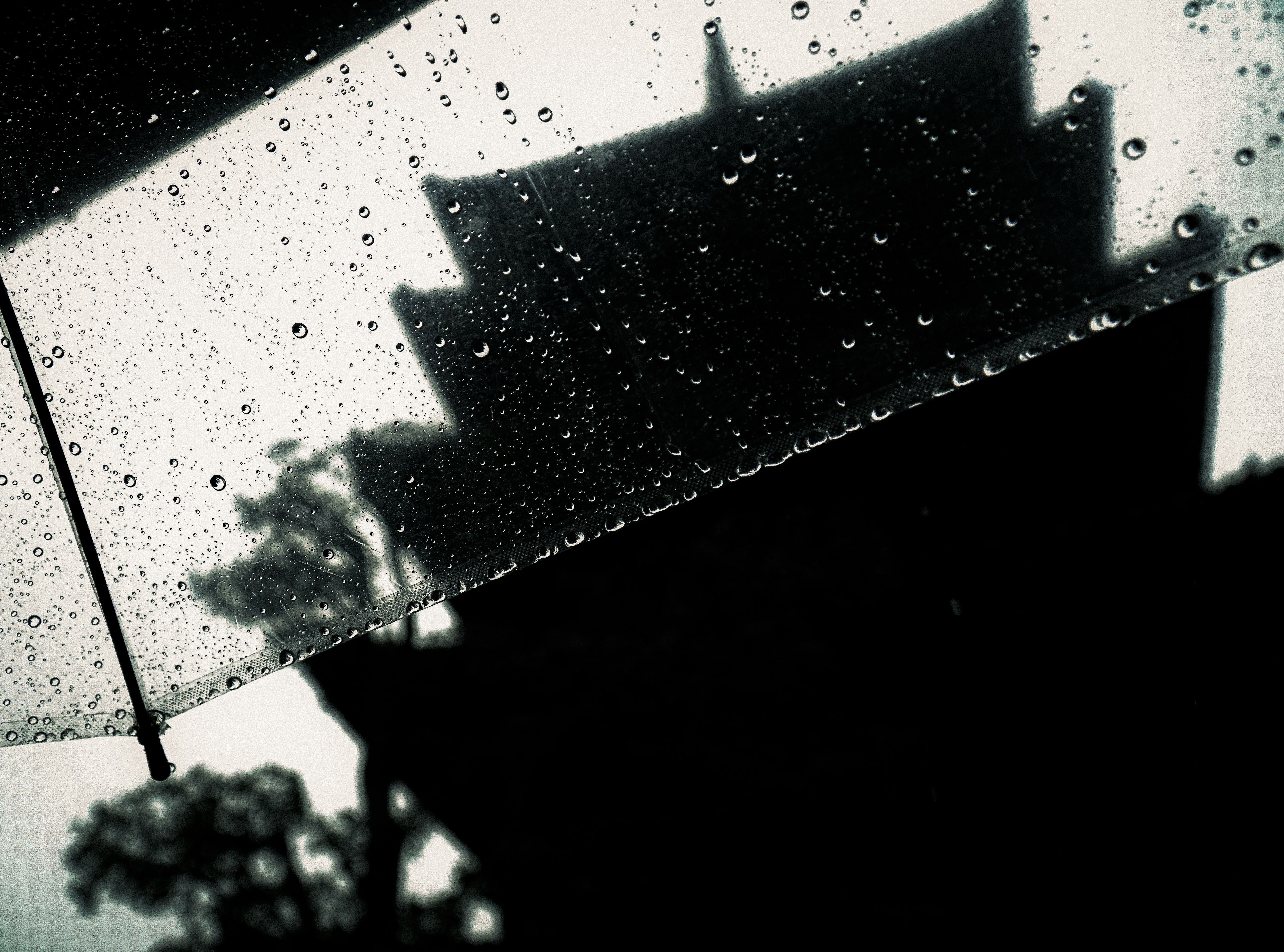 Parapluie avec gouttes de pluie et silhouette d'un bâtiment