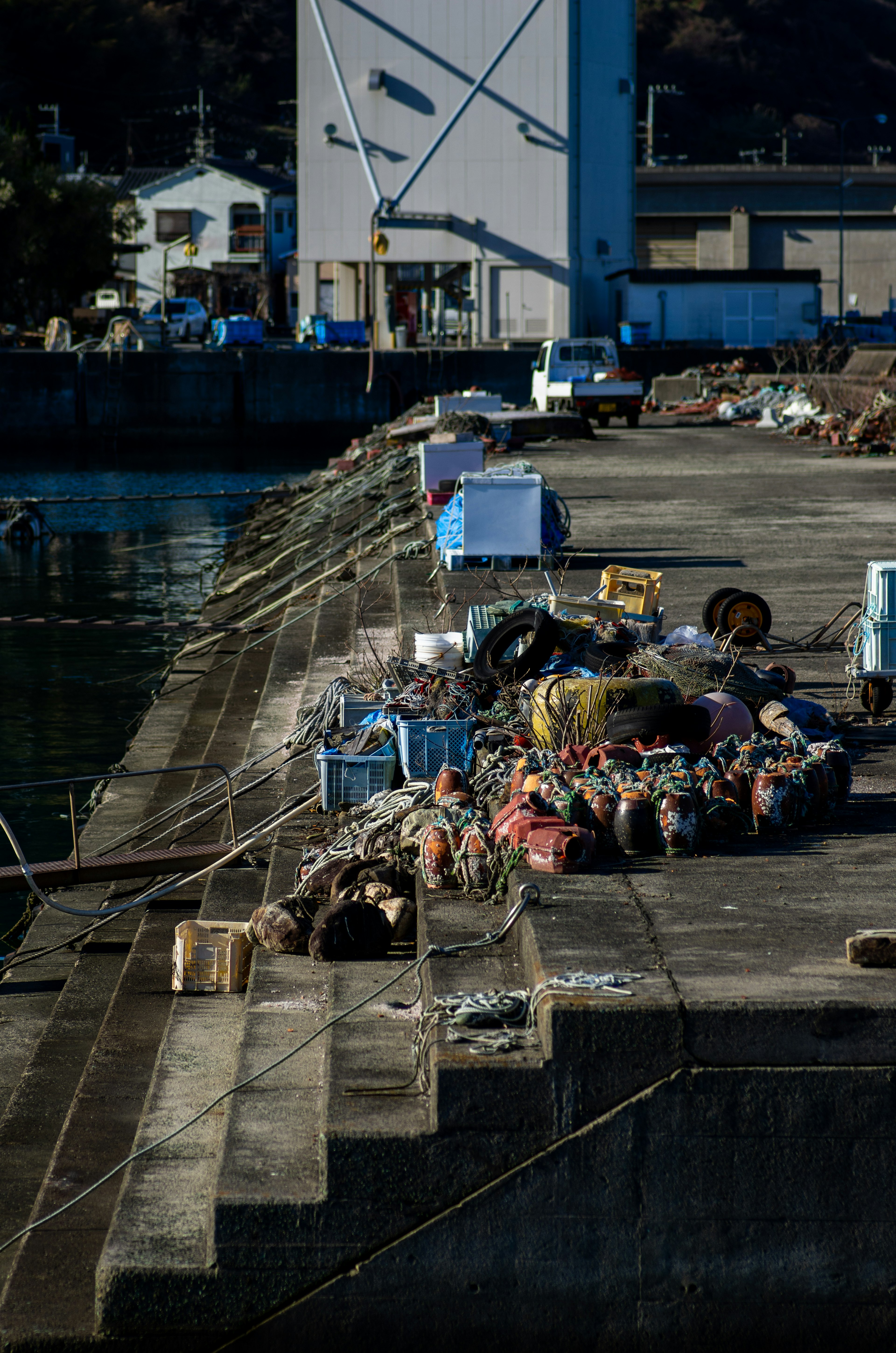 Raggruppamento di attrezzature da pesca e scatole lungo il bordo del porto