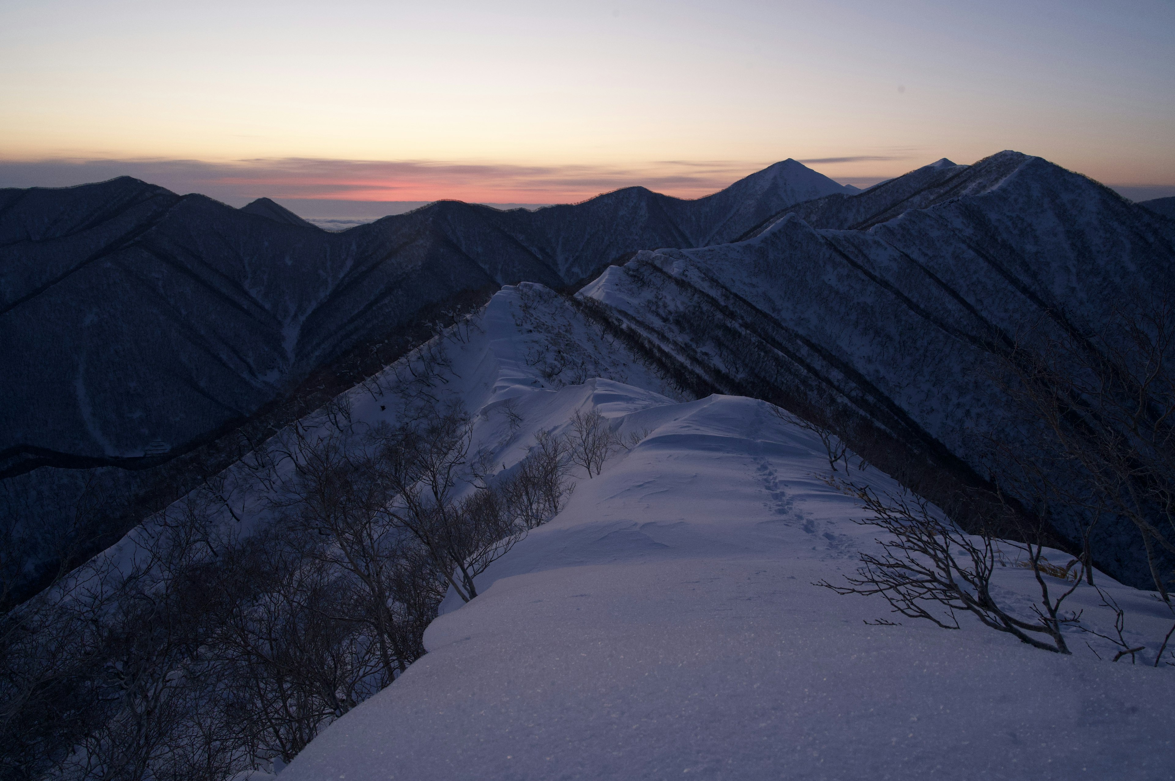 Paesaggio montano coperto di neve con un bellissimo cielo al crepuscolo