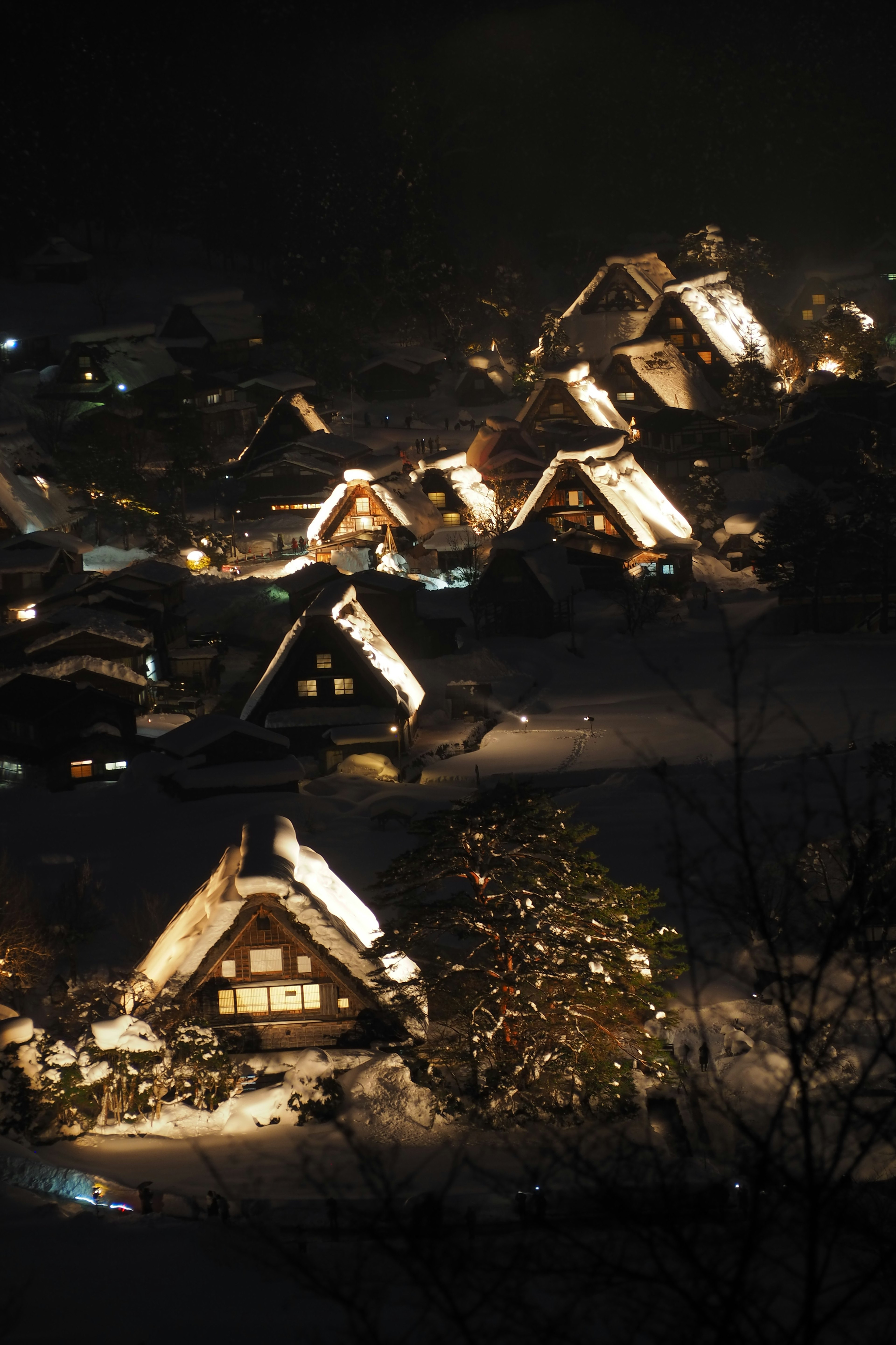 Vista notturna di un villaggio gassho-zukuri coperto di neve