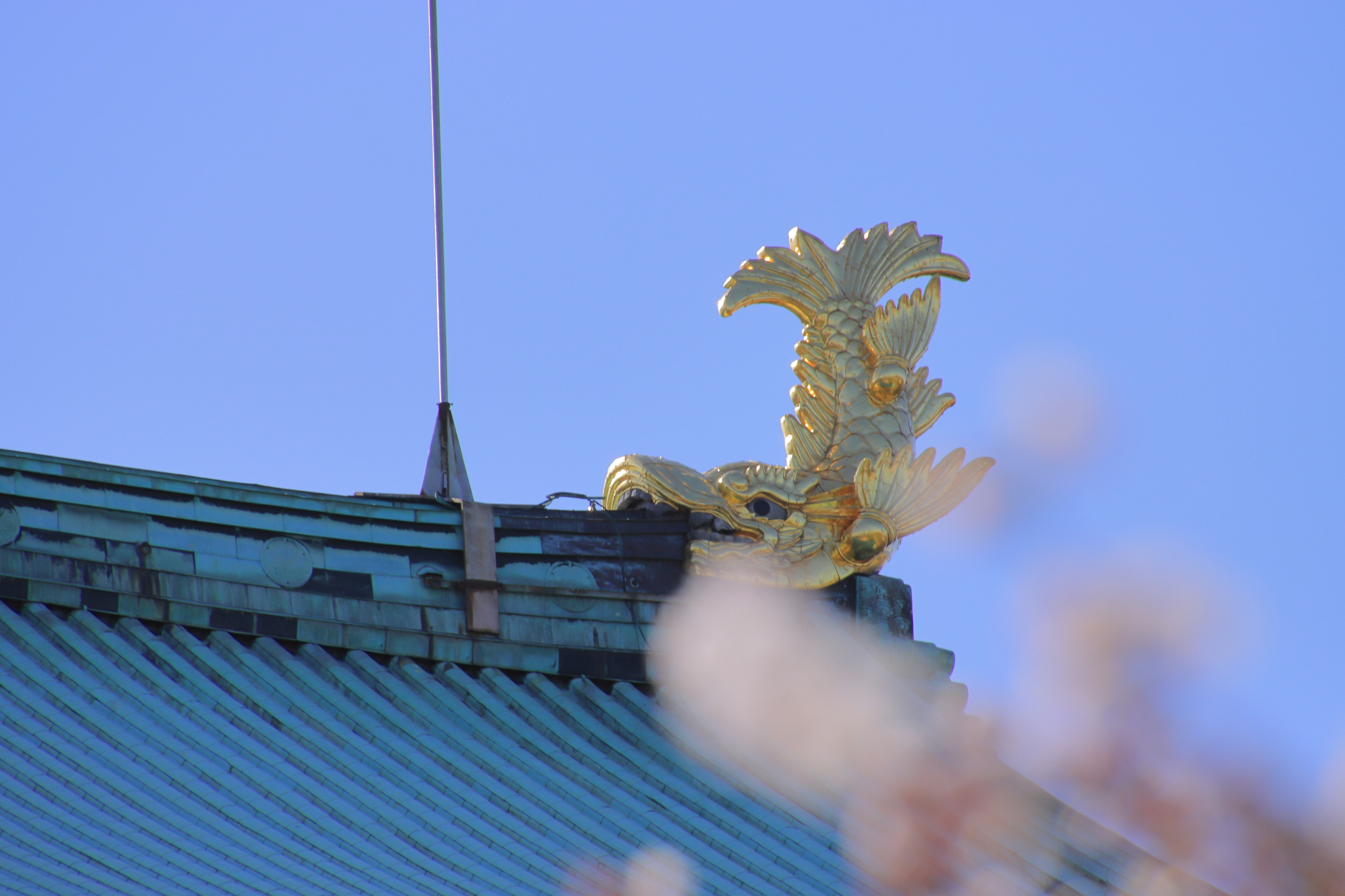 Ornamen elang emas di atap dengan latar belakang langit biru