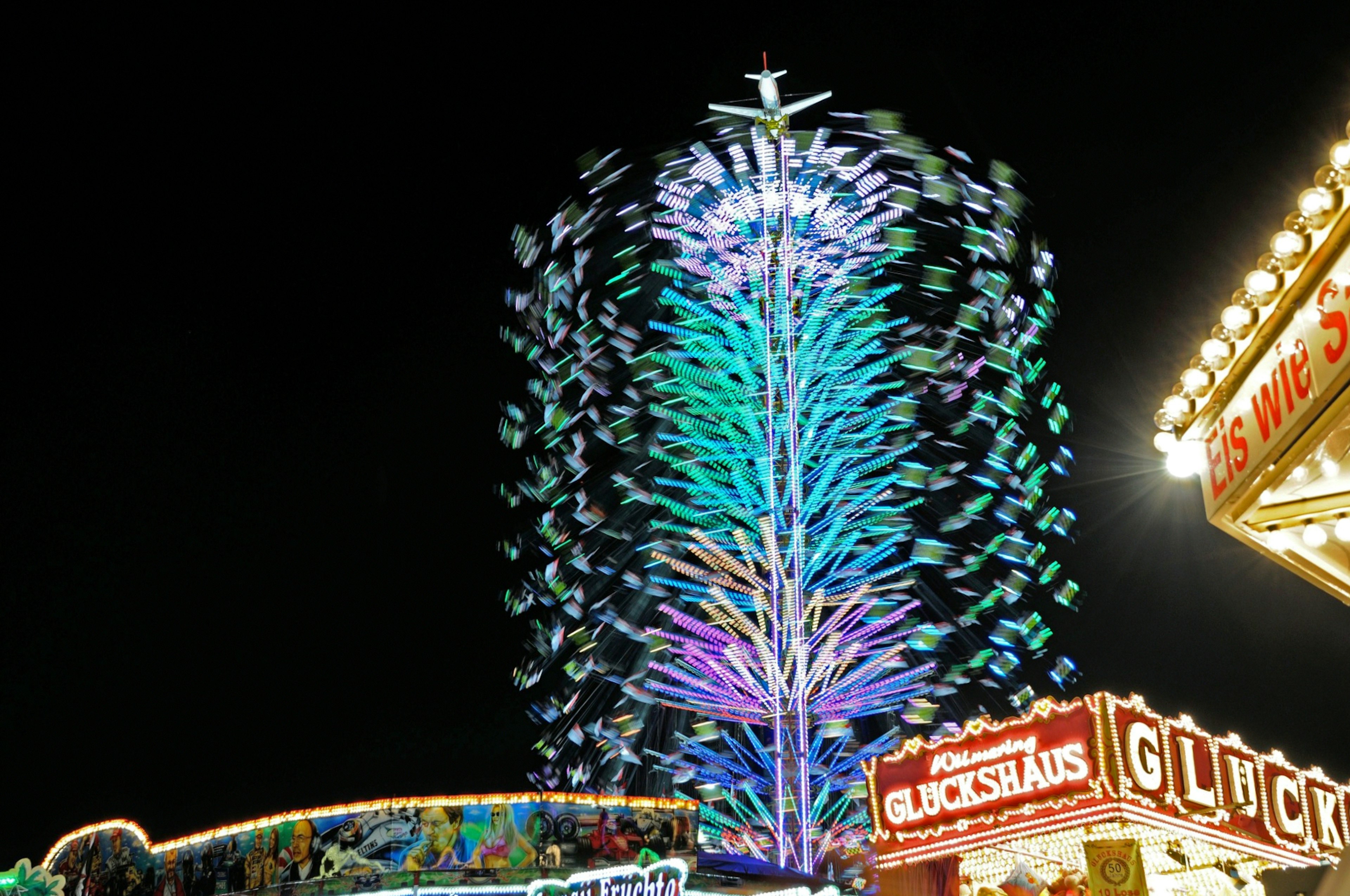 夜空中閃耀的彩色光樹與嘉年華遊樂設施