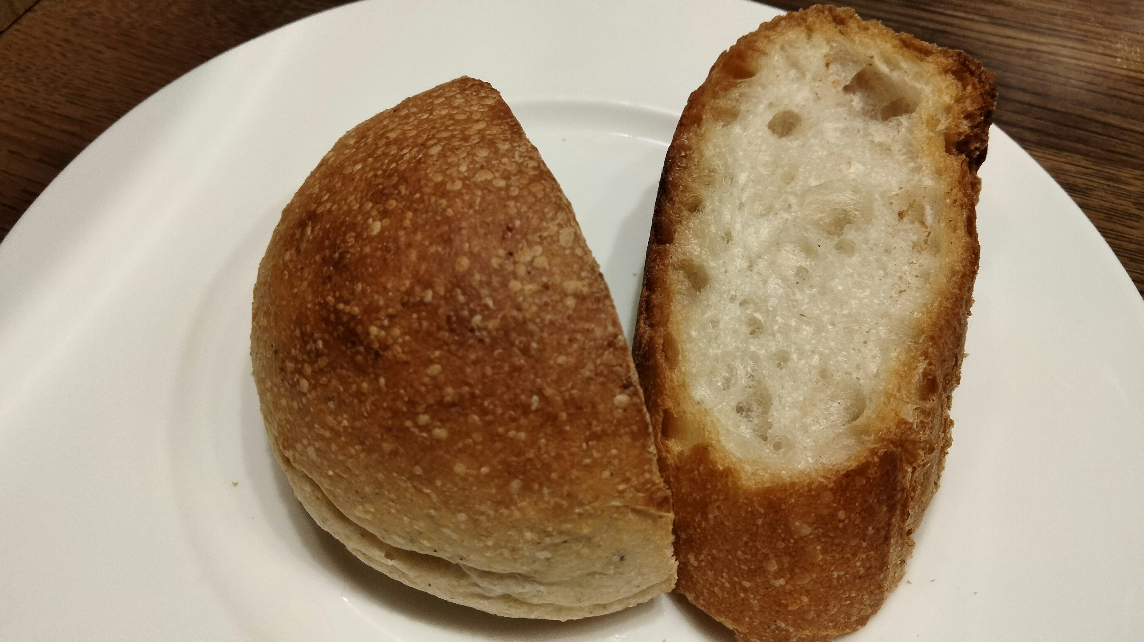 Foto roti yang dipotong dua menunjukkan kulit emas dan bagian dalam putih yang lembut