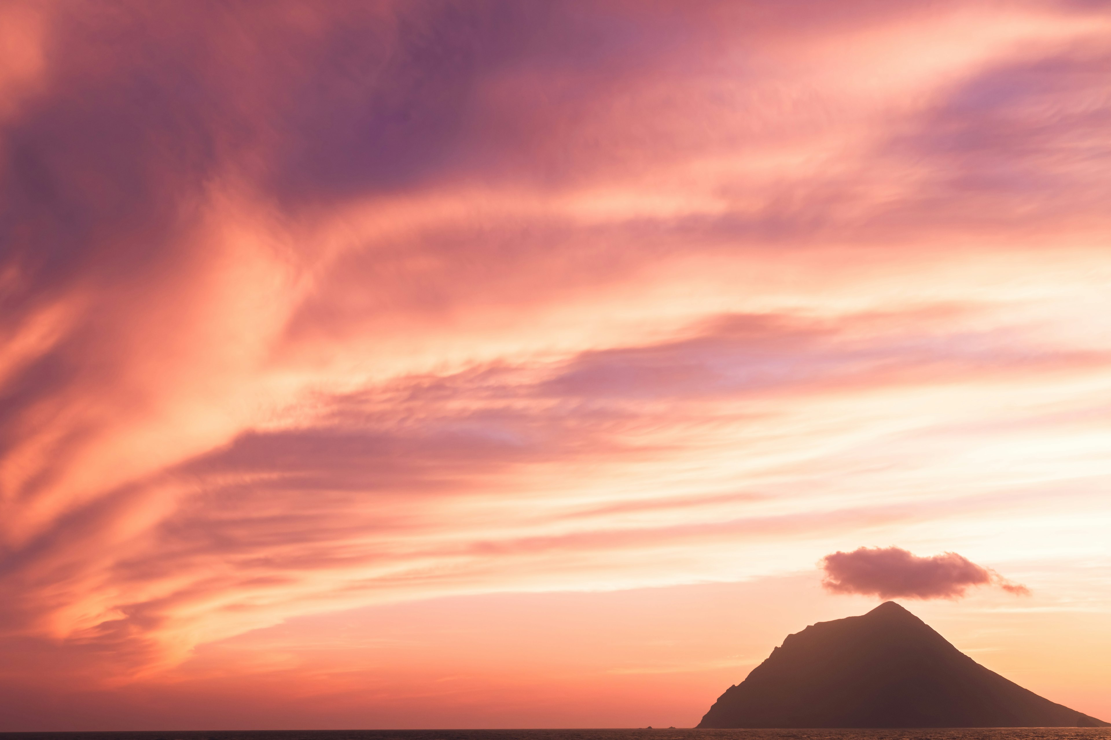 Impresionante cielo al atardecer con la silueta de una montaña lejana