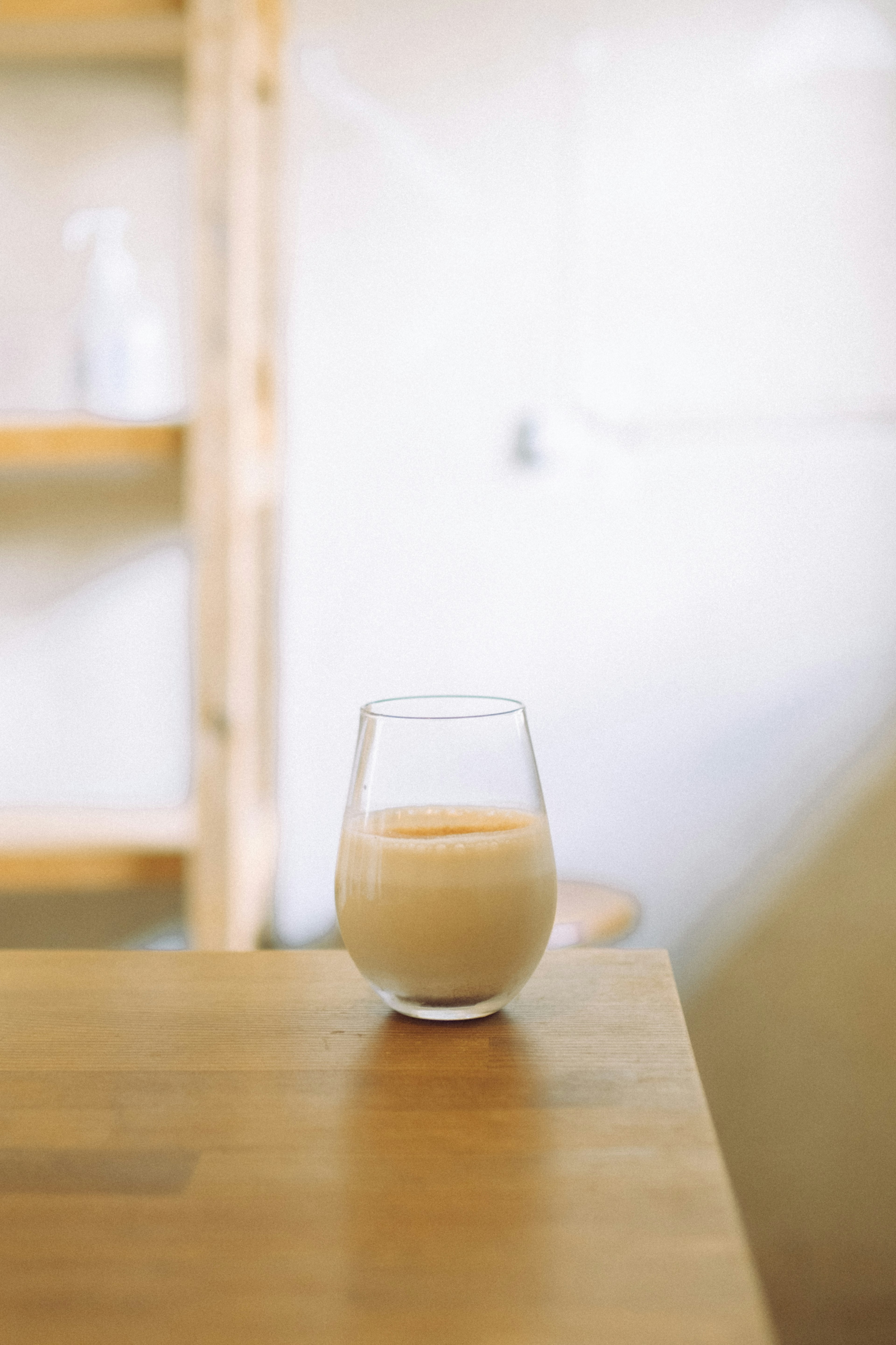 A glass of beverage on a wooden table