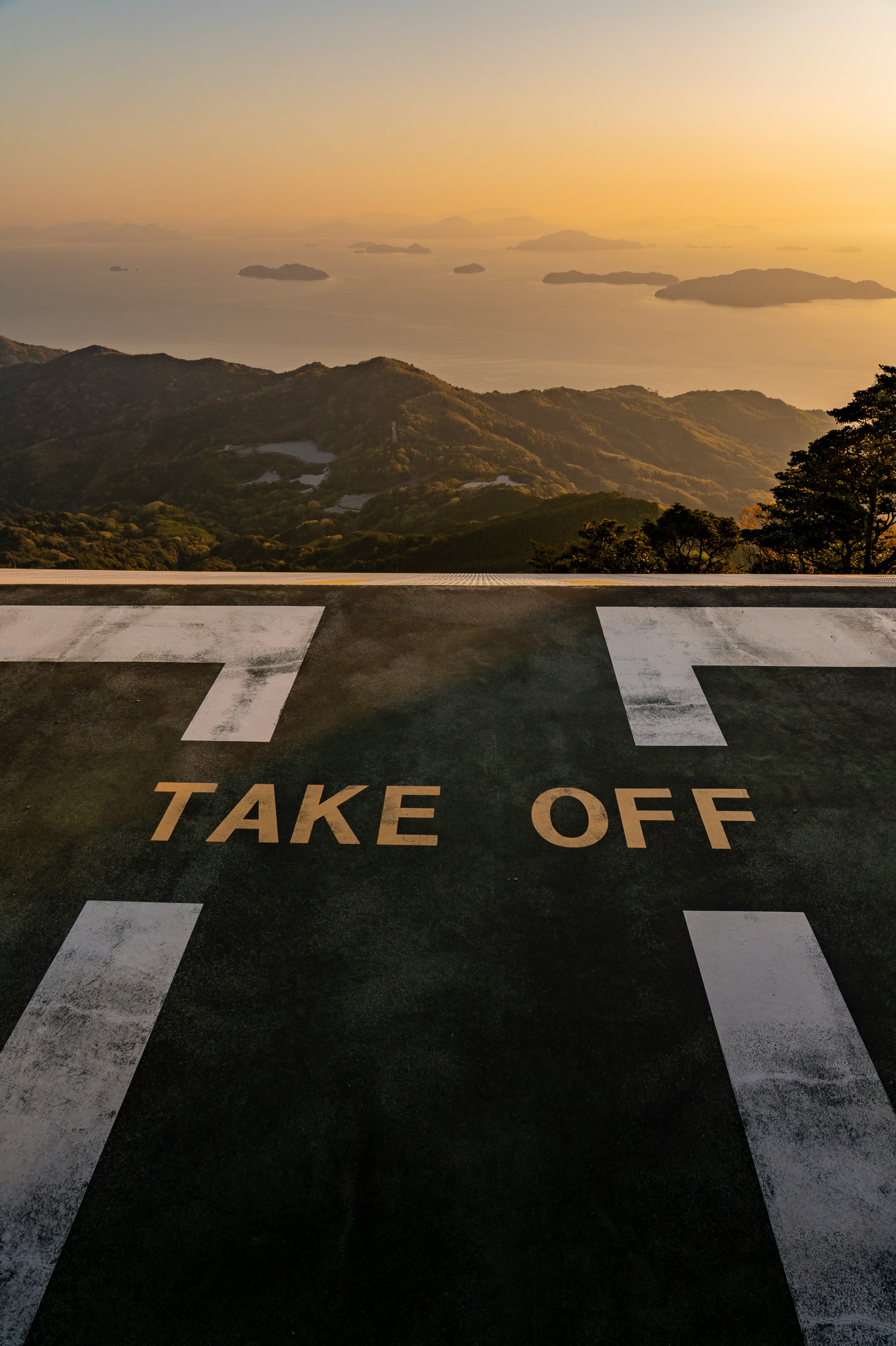 Héliport avec le texte 'TAKE OFF' sur fond de coucher de soleil