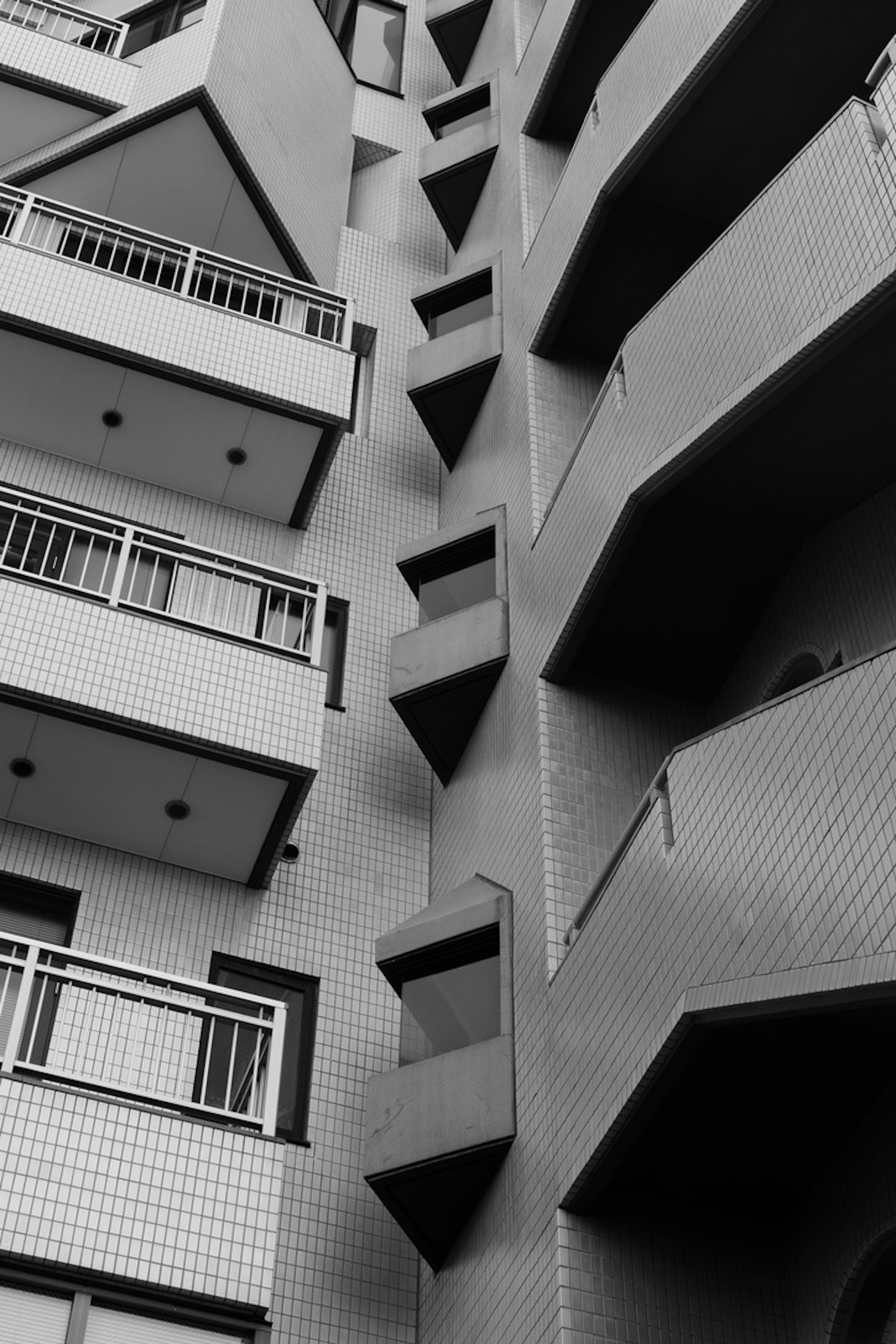 Black and white image of a modern building featuring unique stepped balconies