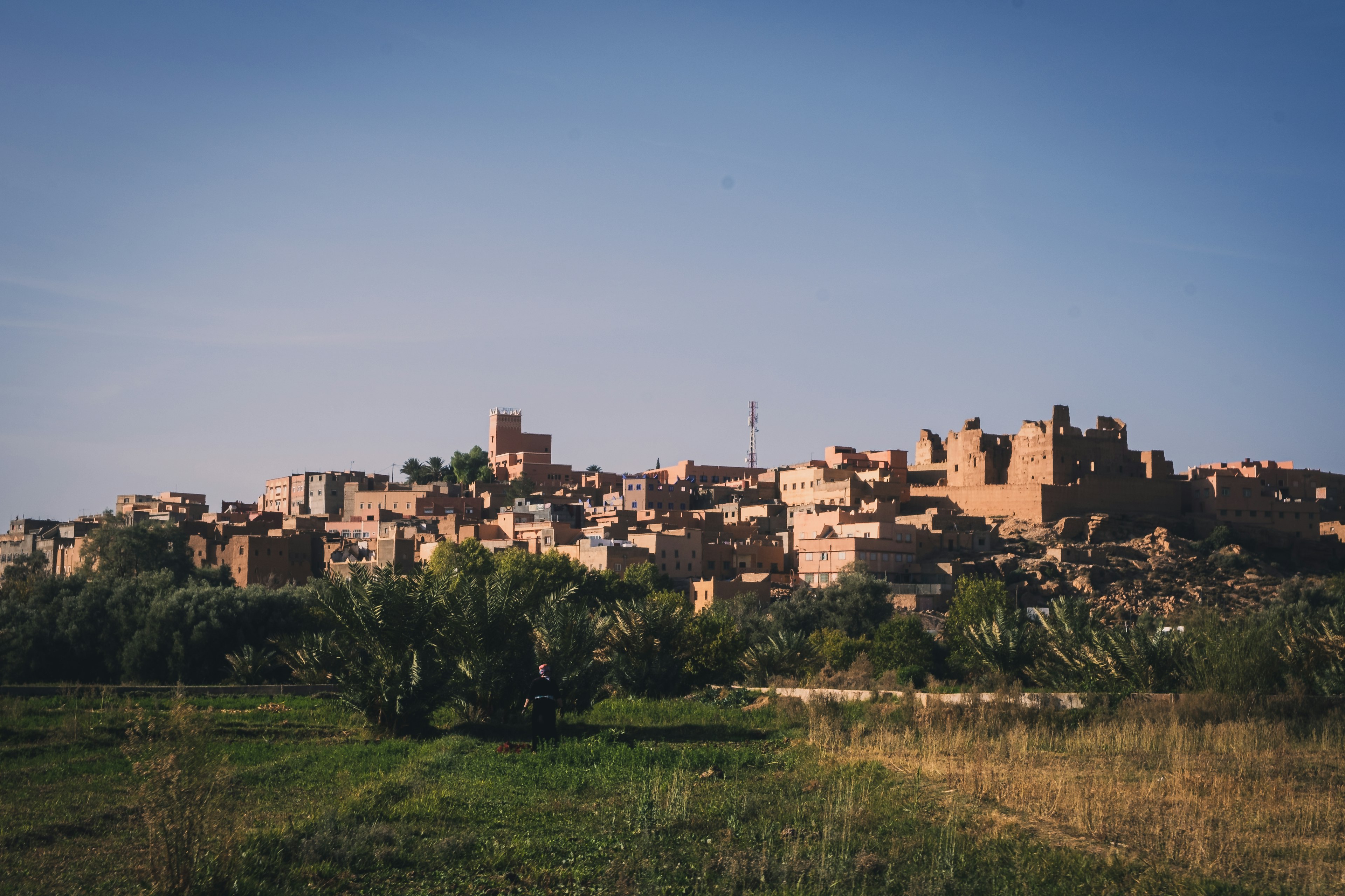 Une vue pittoresque d'un vieux village sous un ciel bleu avec une herbe verte et des bâtiments en terre