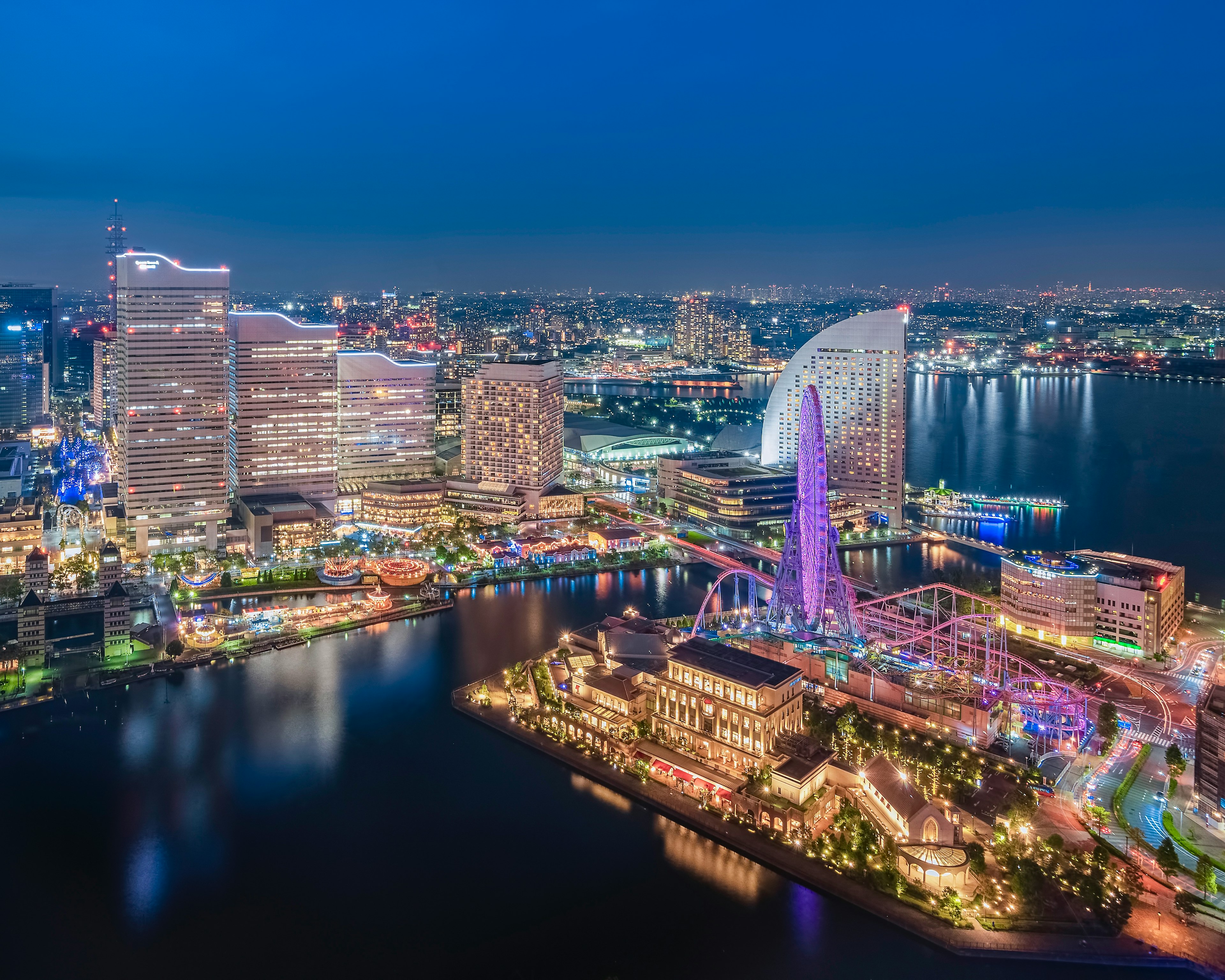 Vue nocturne de Yokohama avec des gratte-ciels modernes et le bord de mer illuminé de lumières colorées