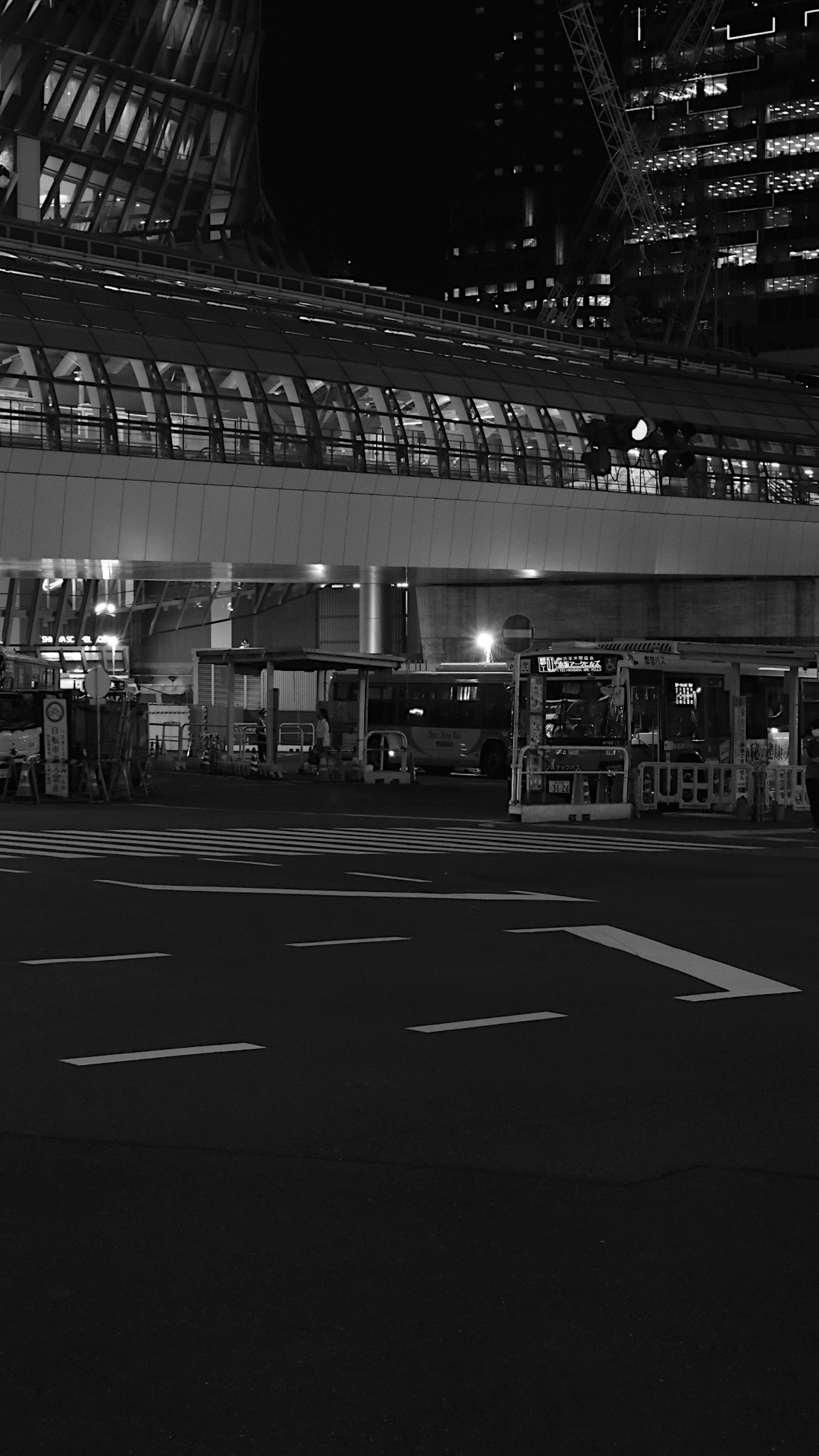 Paesaggio urbano notturno con una fermata dell'autobus e elementi architettonici moderni