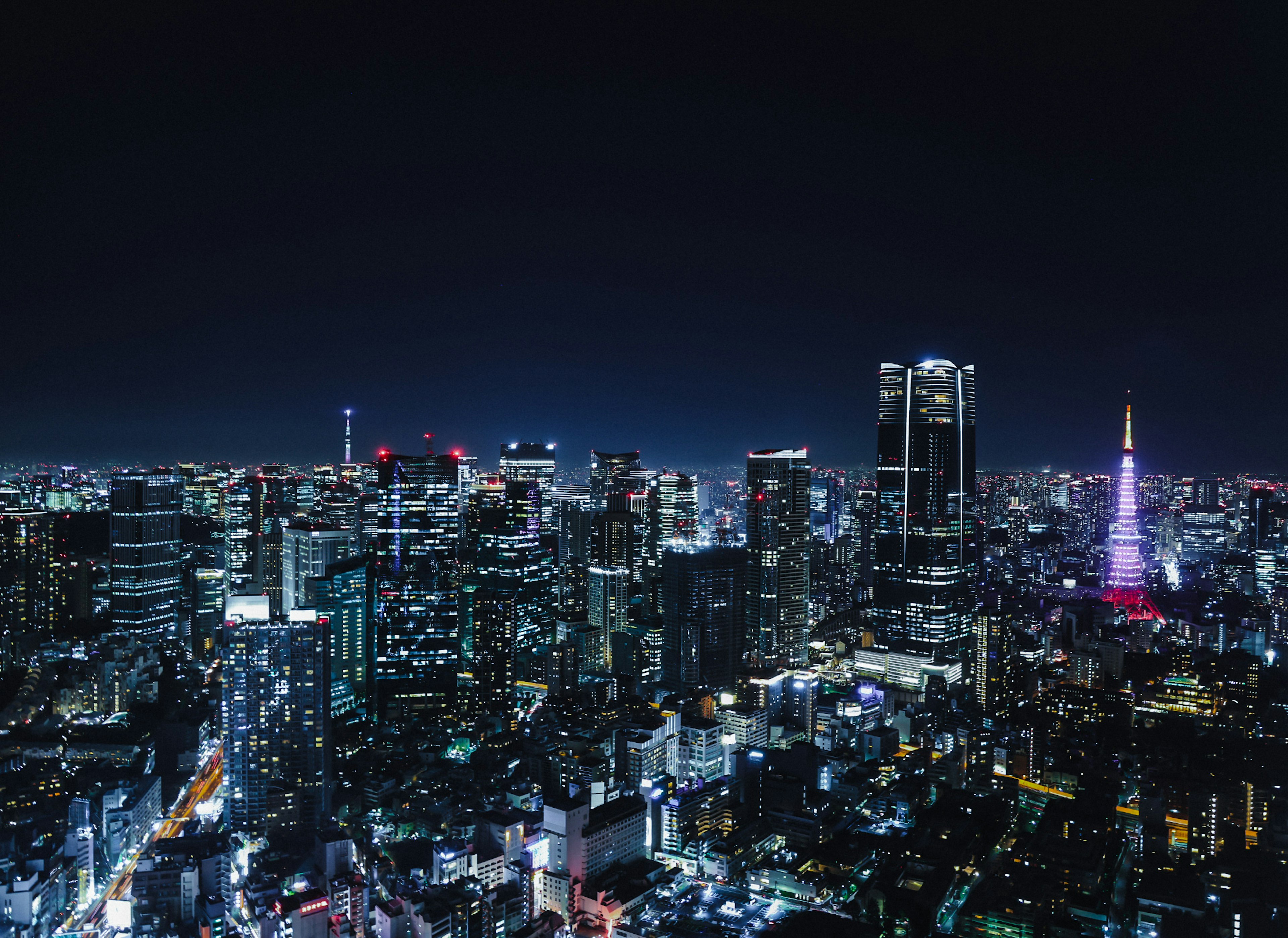 Skyline di Tokyo di notte con grattacieli illuminati e Torre di Tokyo