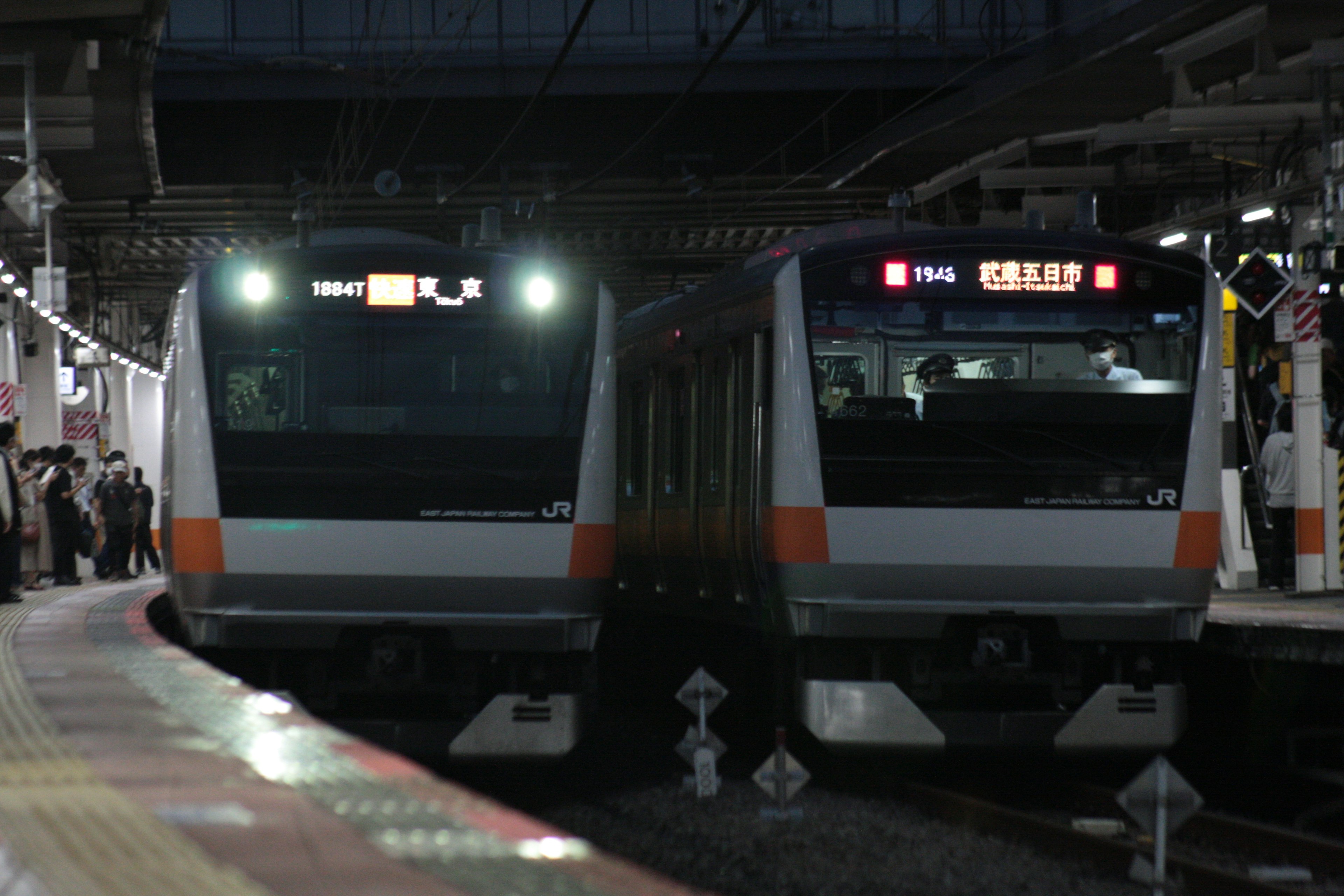 Dos trenes parados en una estación de noche