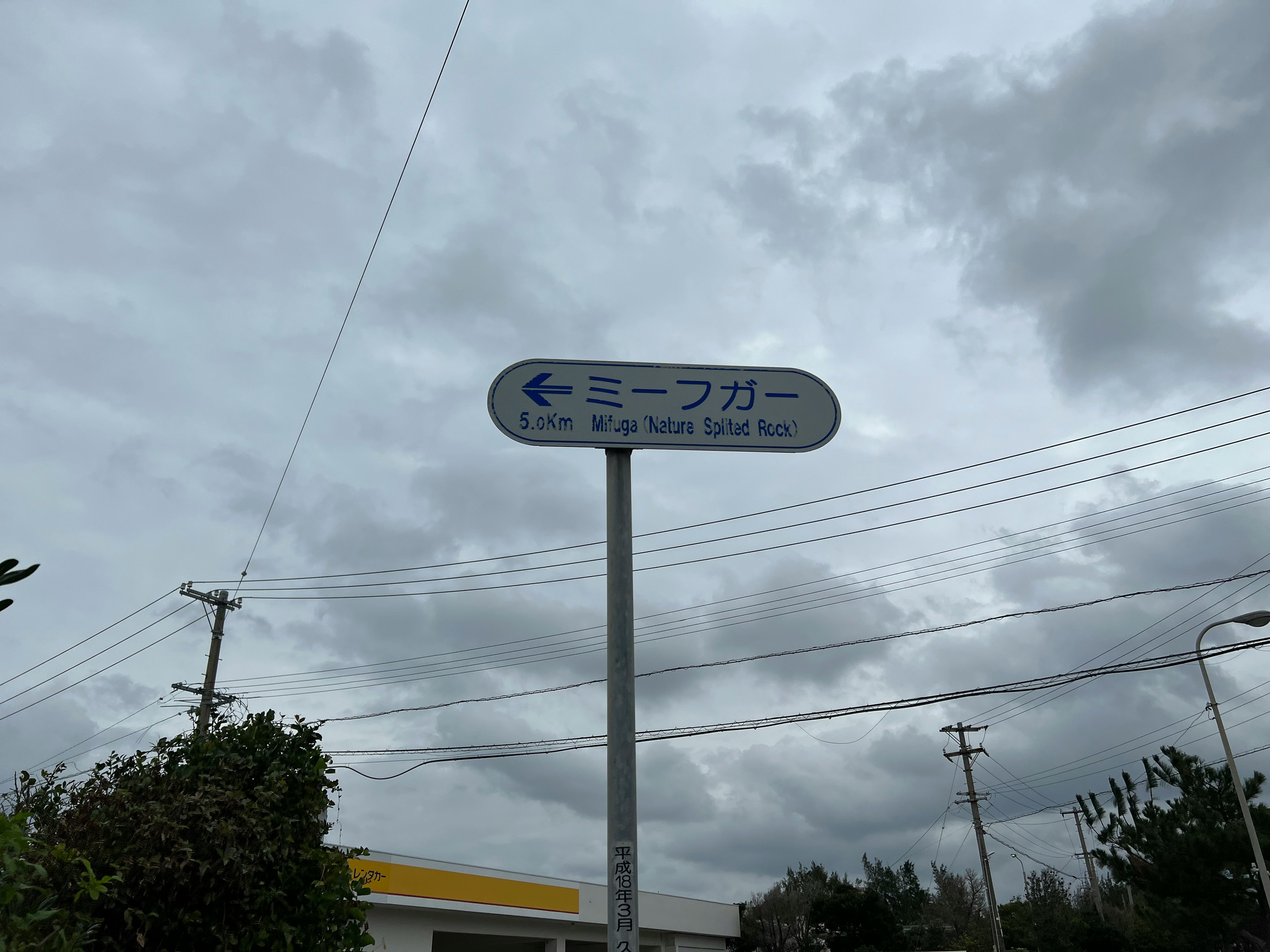 Directional sign showing Miipugaa with cloudy sky