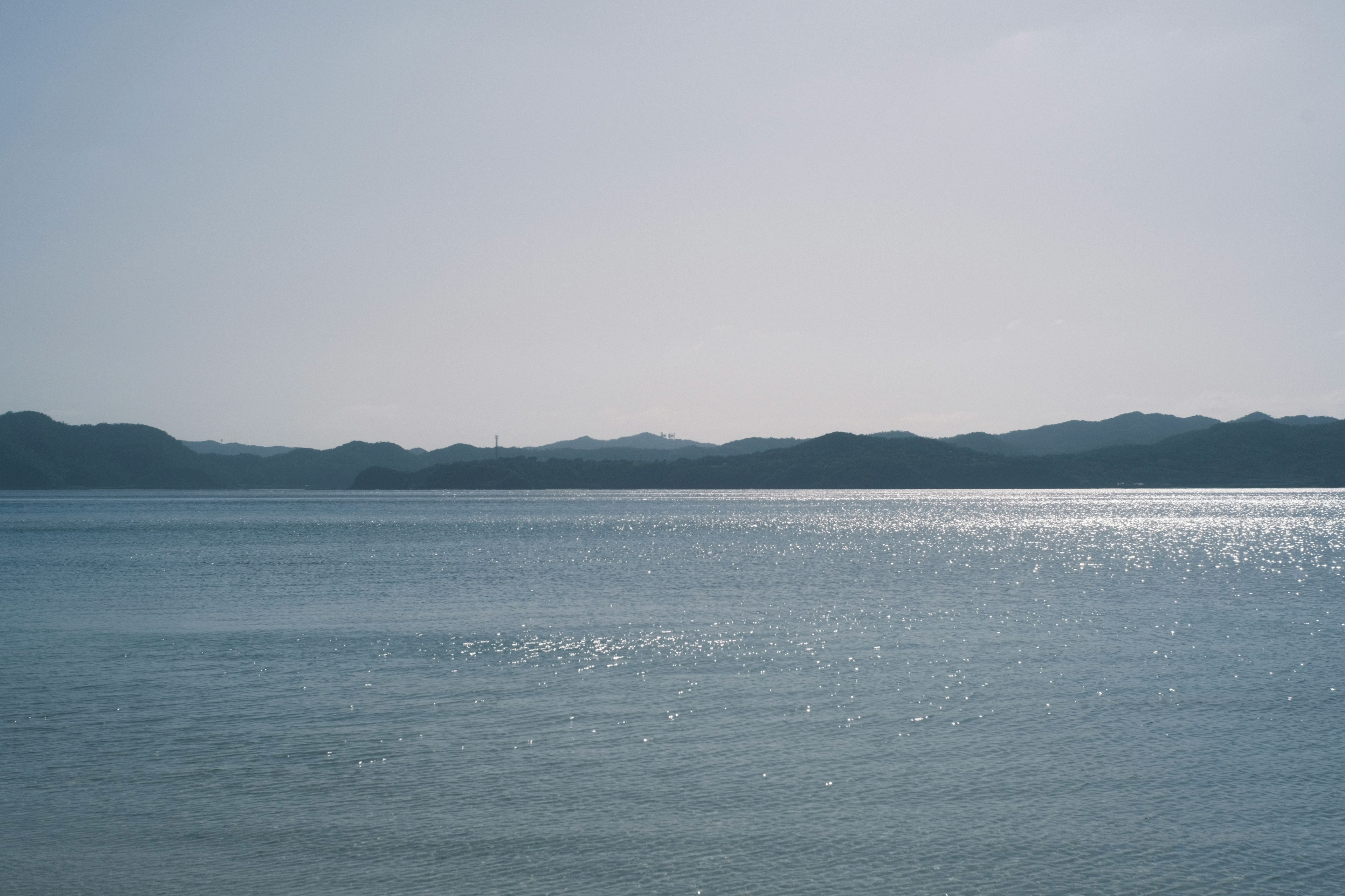 静かな海の景色と遠くの山々