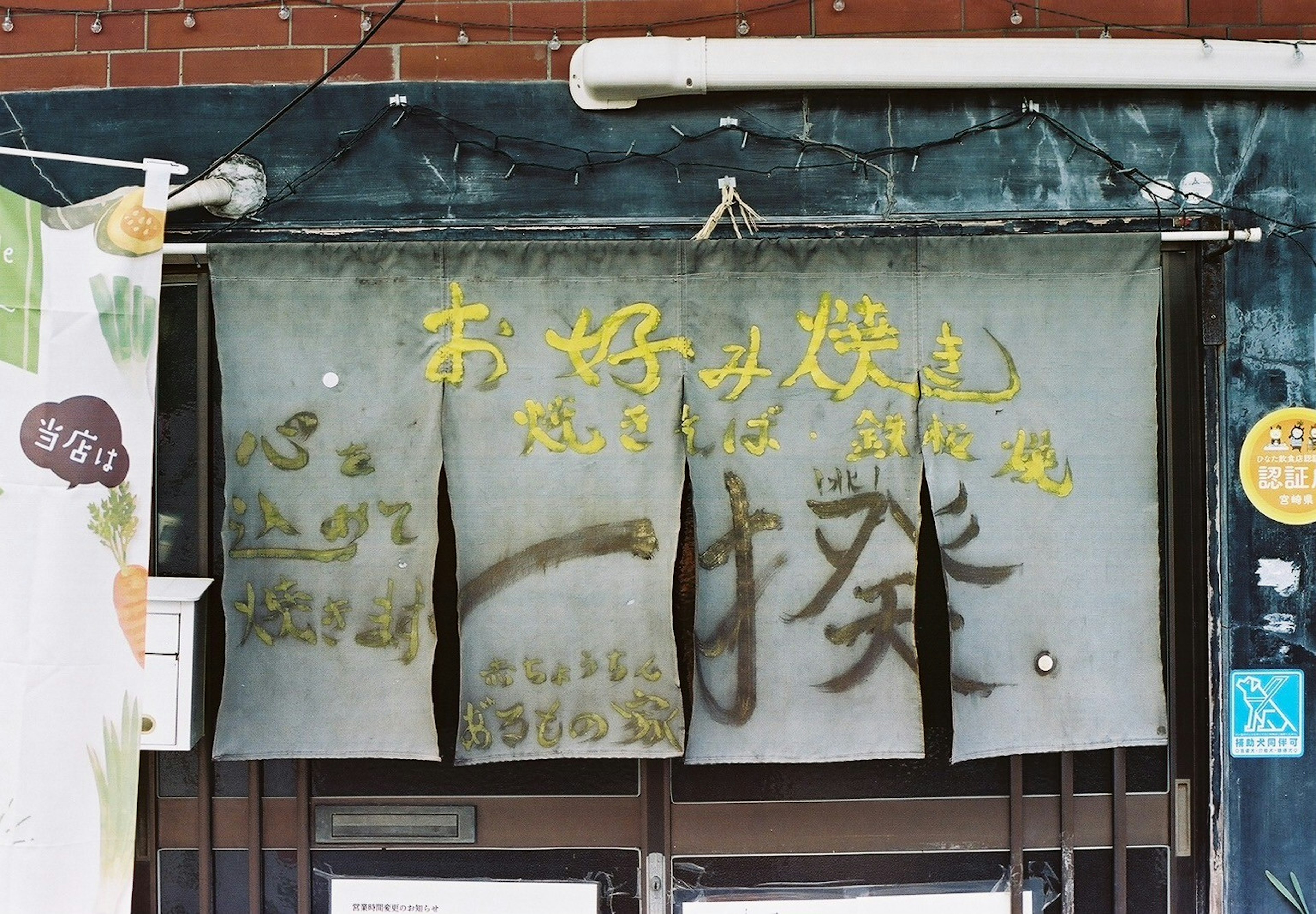 Noren de un restaurante japonés tradicional con letrero manuscrito y colores desvanecidos