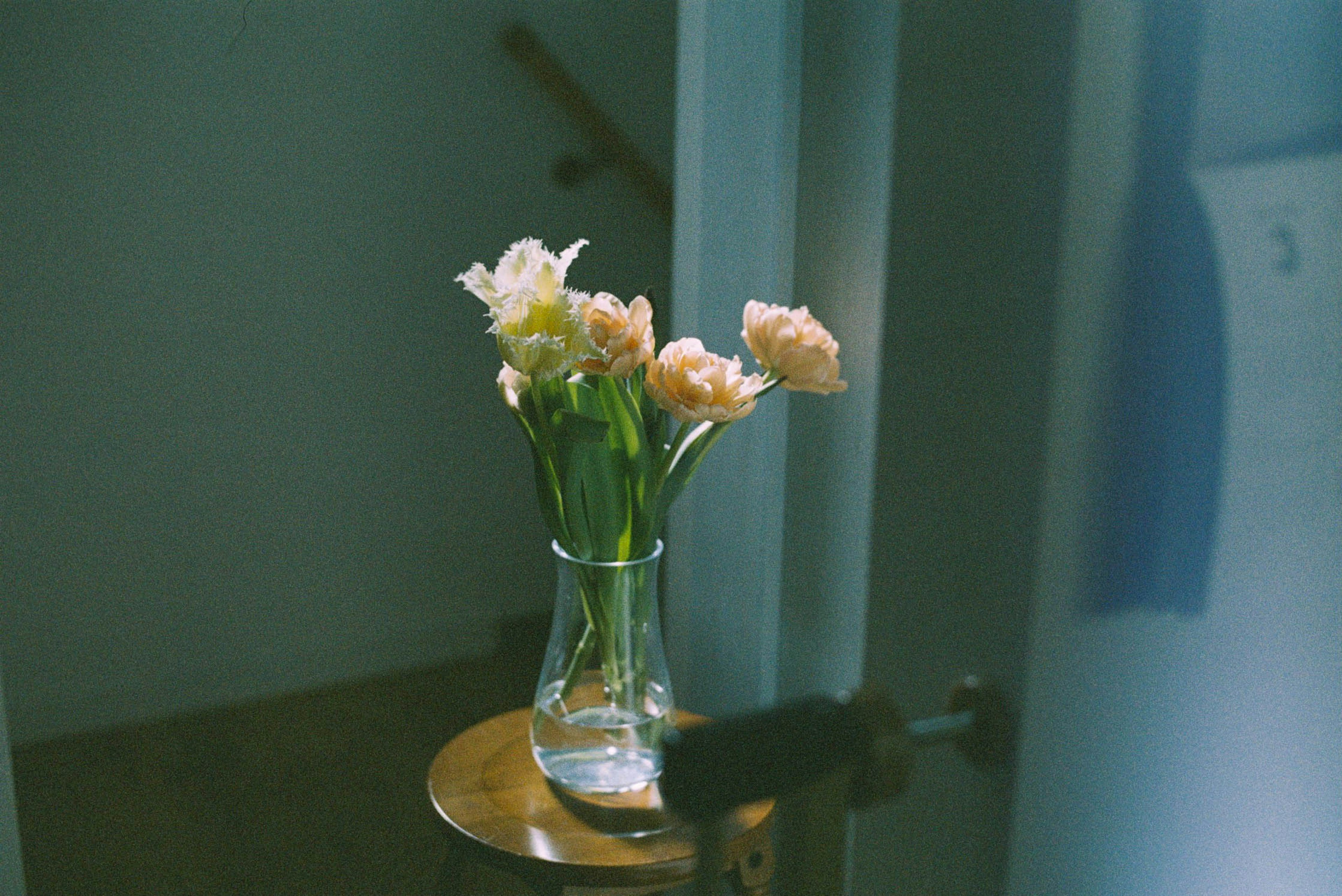 Indoor scene with a vase of pink flowers on a wooden table