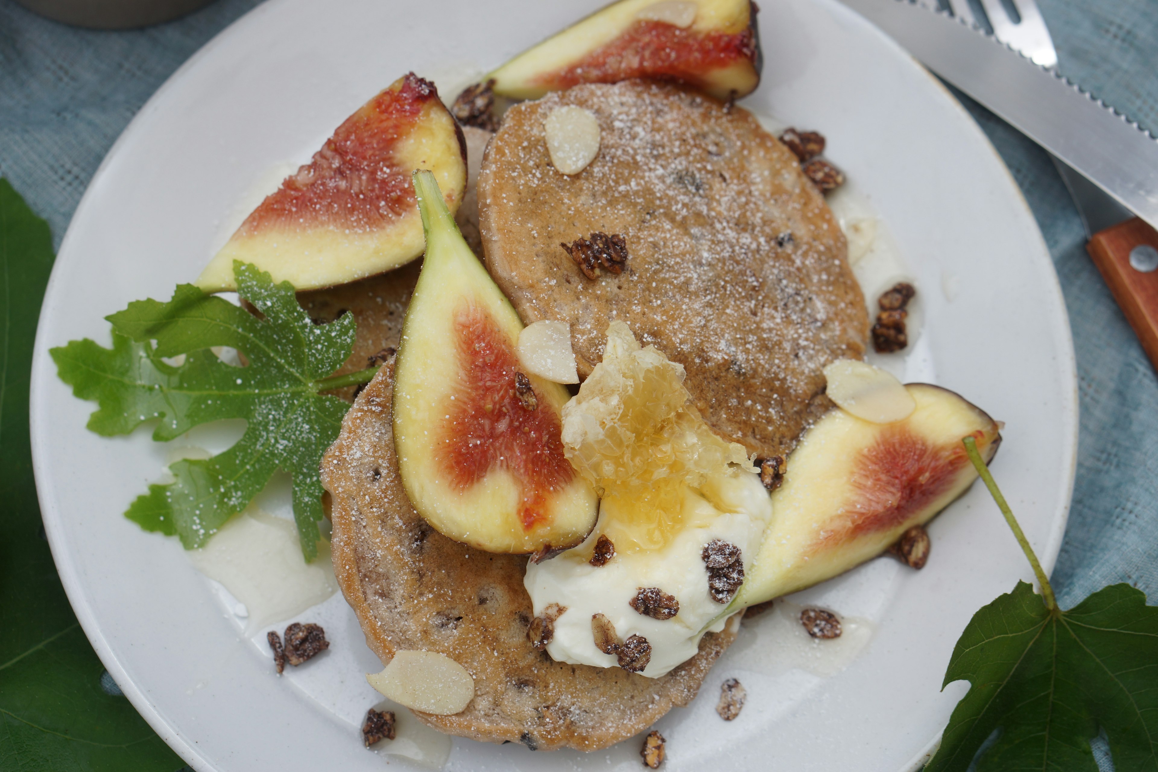 Panqueques servidos con rodajas de higo fresco y decorados con nueces