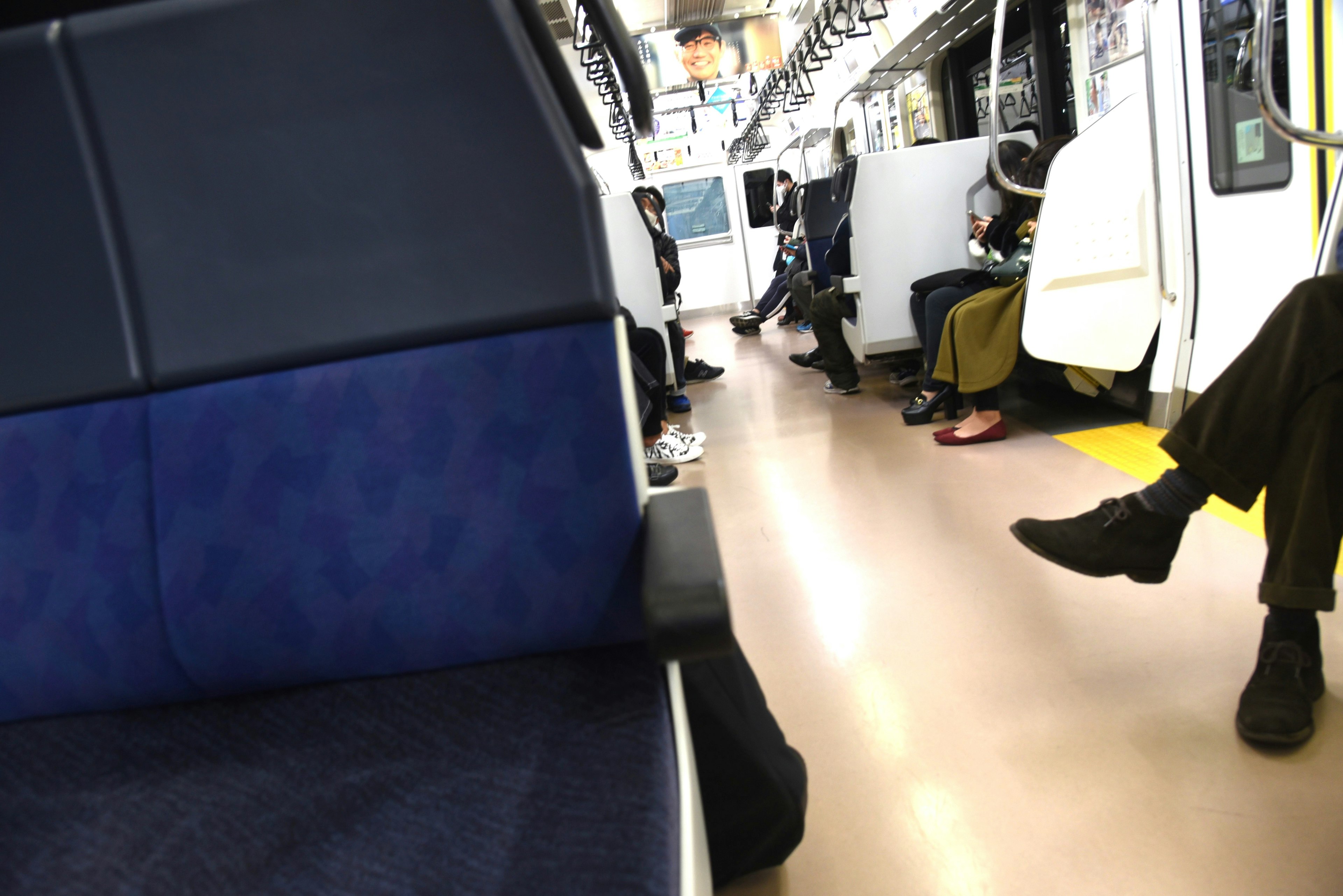 Interior of a train with blue seats and passengers