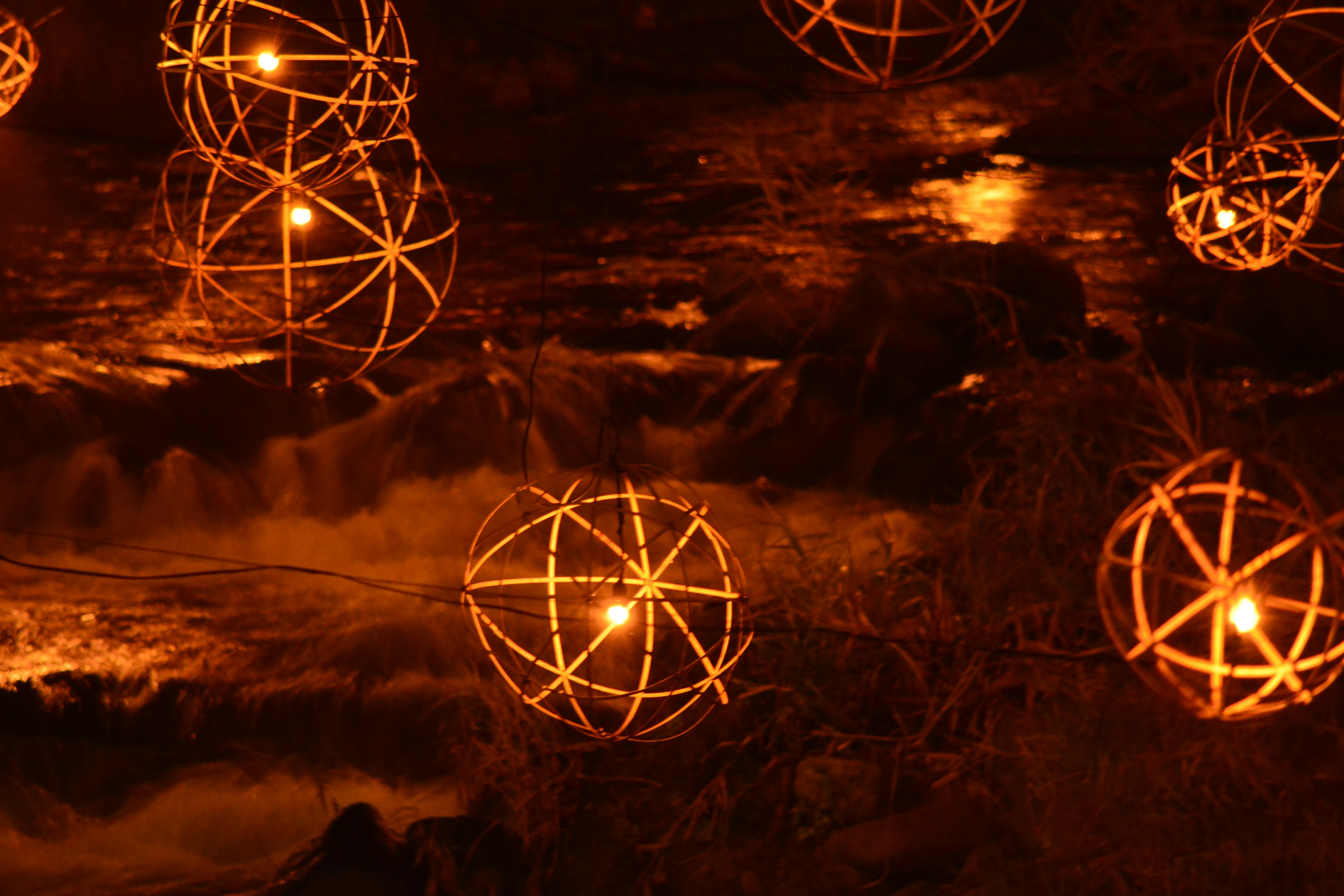 Night scene featuring glowing spherical decorations floating on water