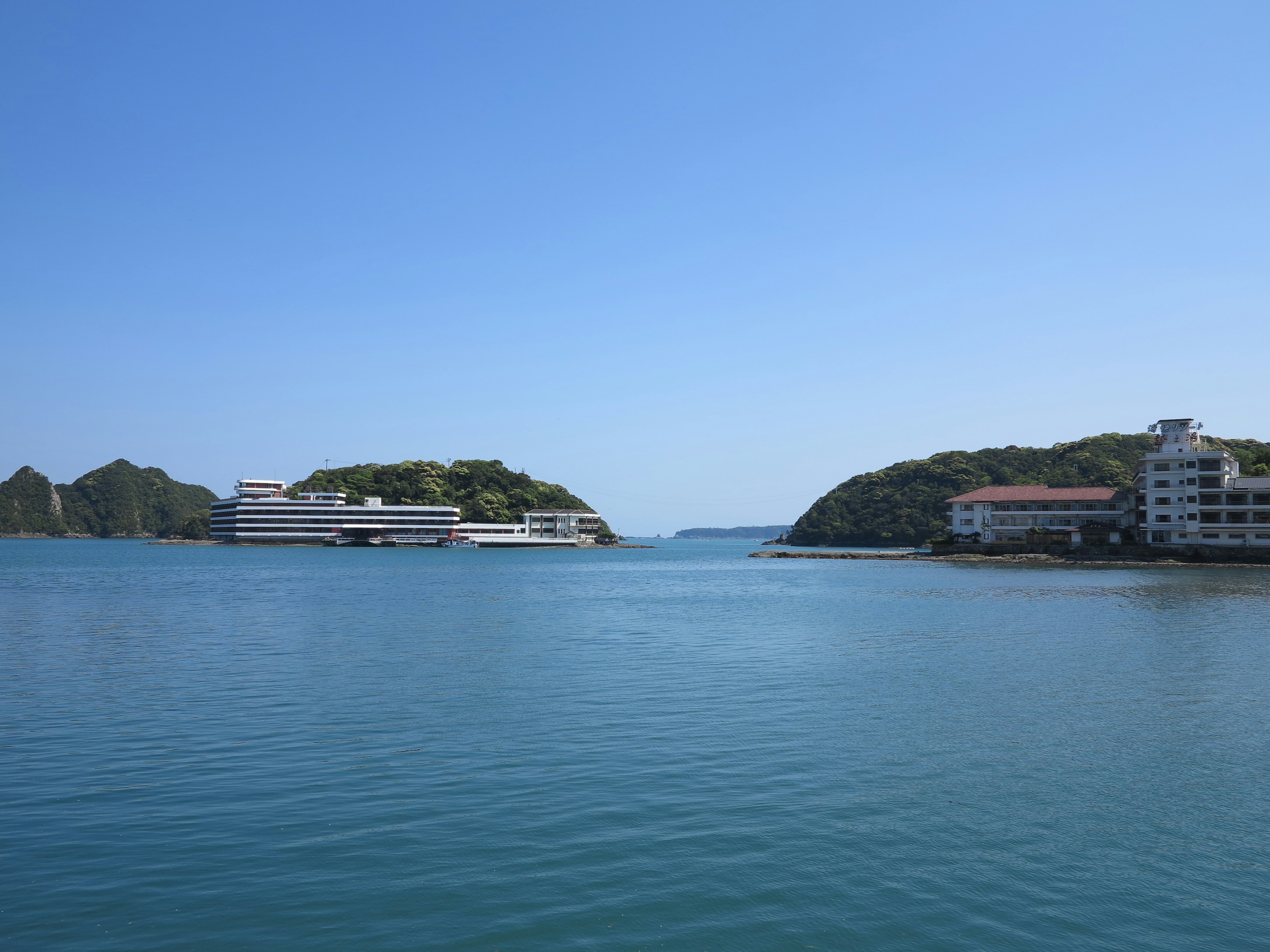 青い空と静かな水面の海に浮かぶ建物の風景