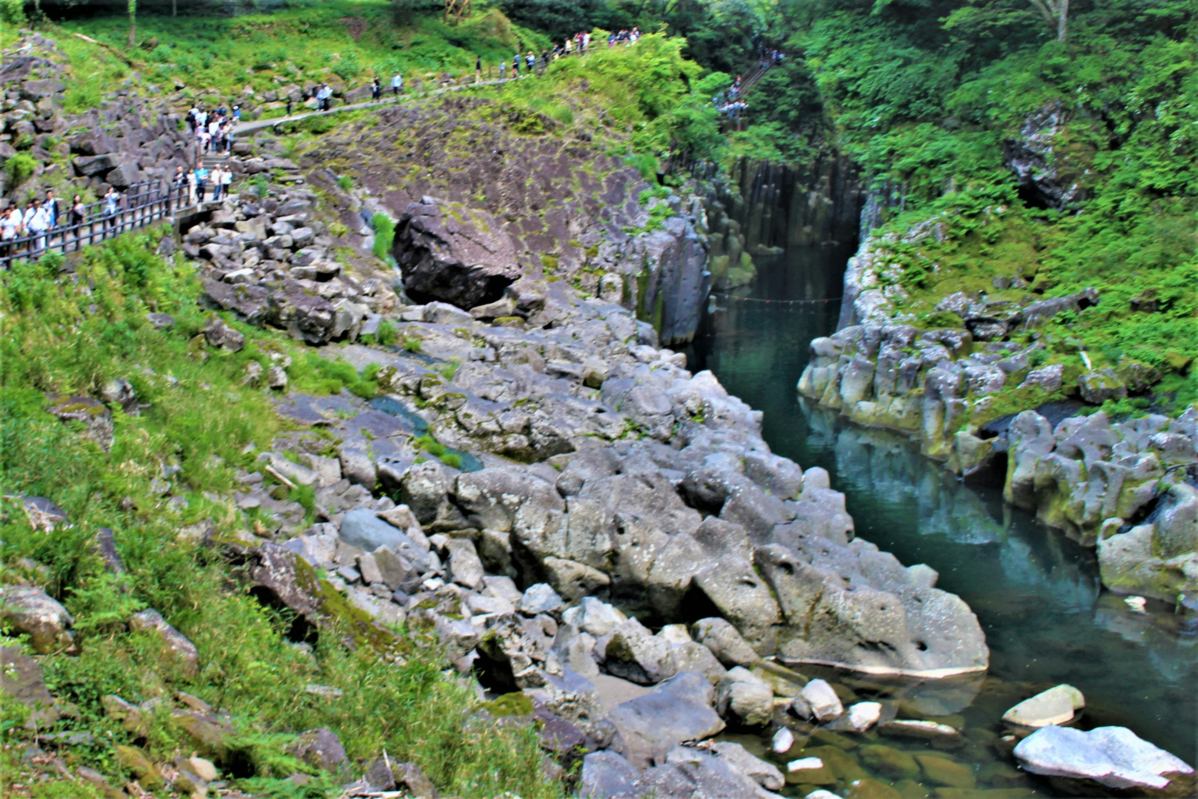 Szenische Aussicht auf einen Fluss mit großen Felsen in einem üppigen Tal