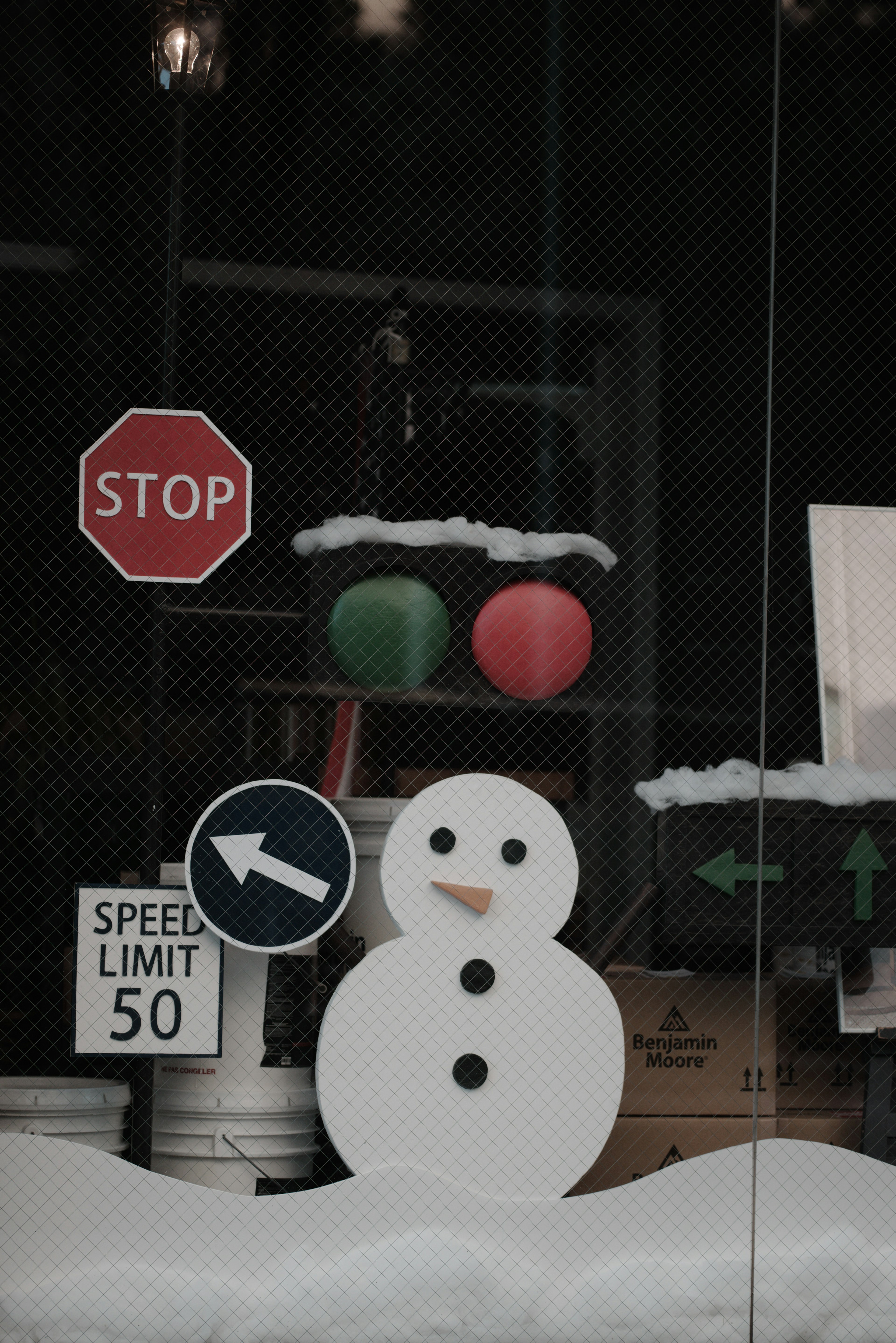 Decoración de ventana invernal con un muñeco de nieve y señales de tráfico