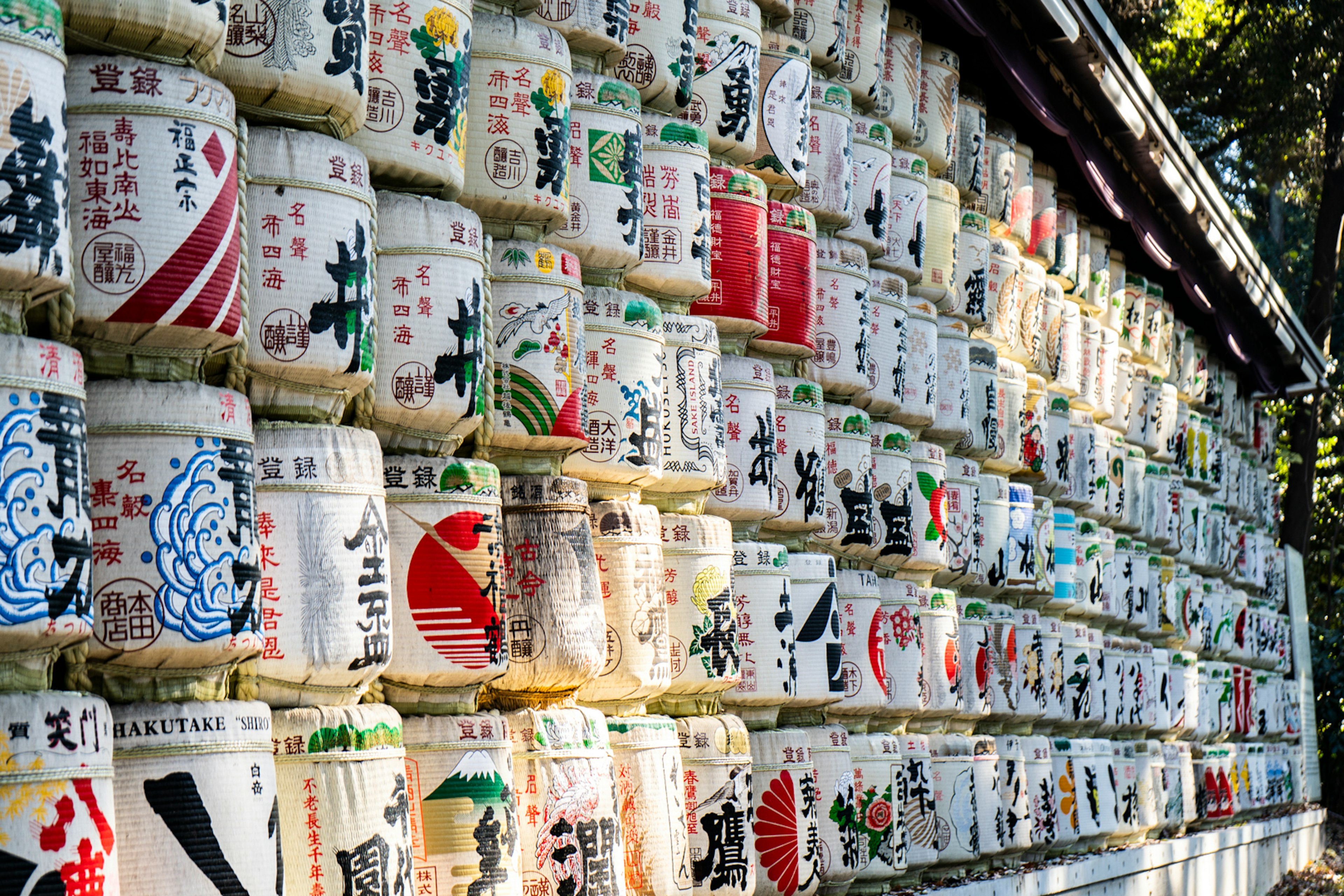 Image of a wall lined with sake barrels featuring colorful designs