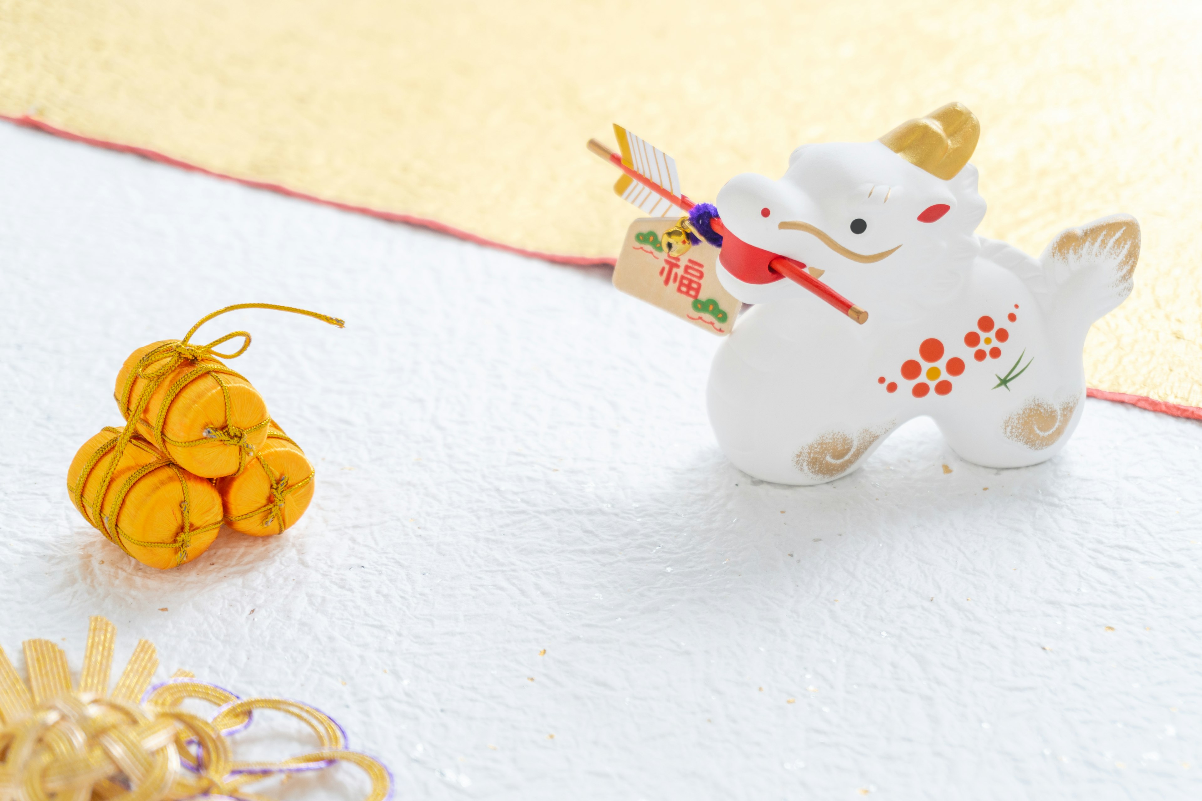 A white zodiac horse figurine with a decorative tag alongside yellow ornaments