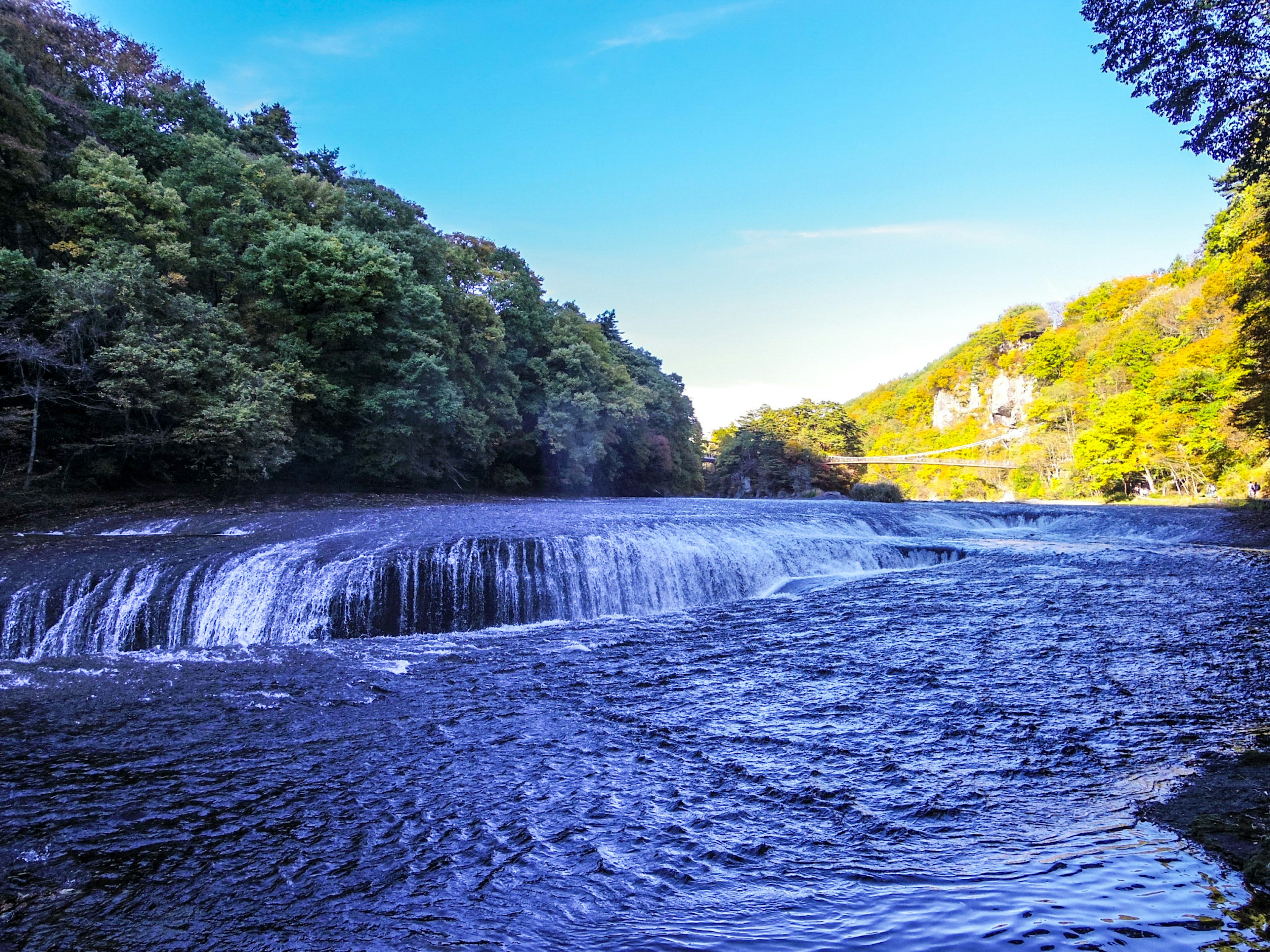 Hermoso paisaje de río y cascada bajo un cielo azul