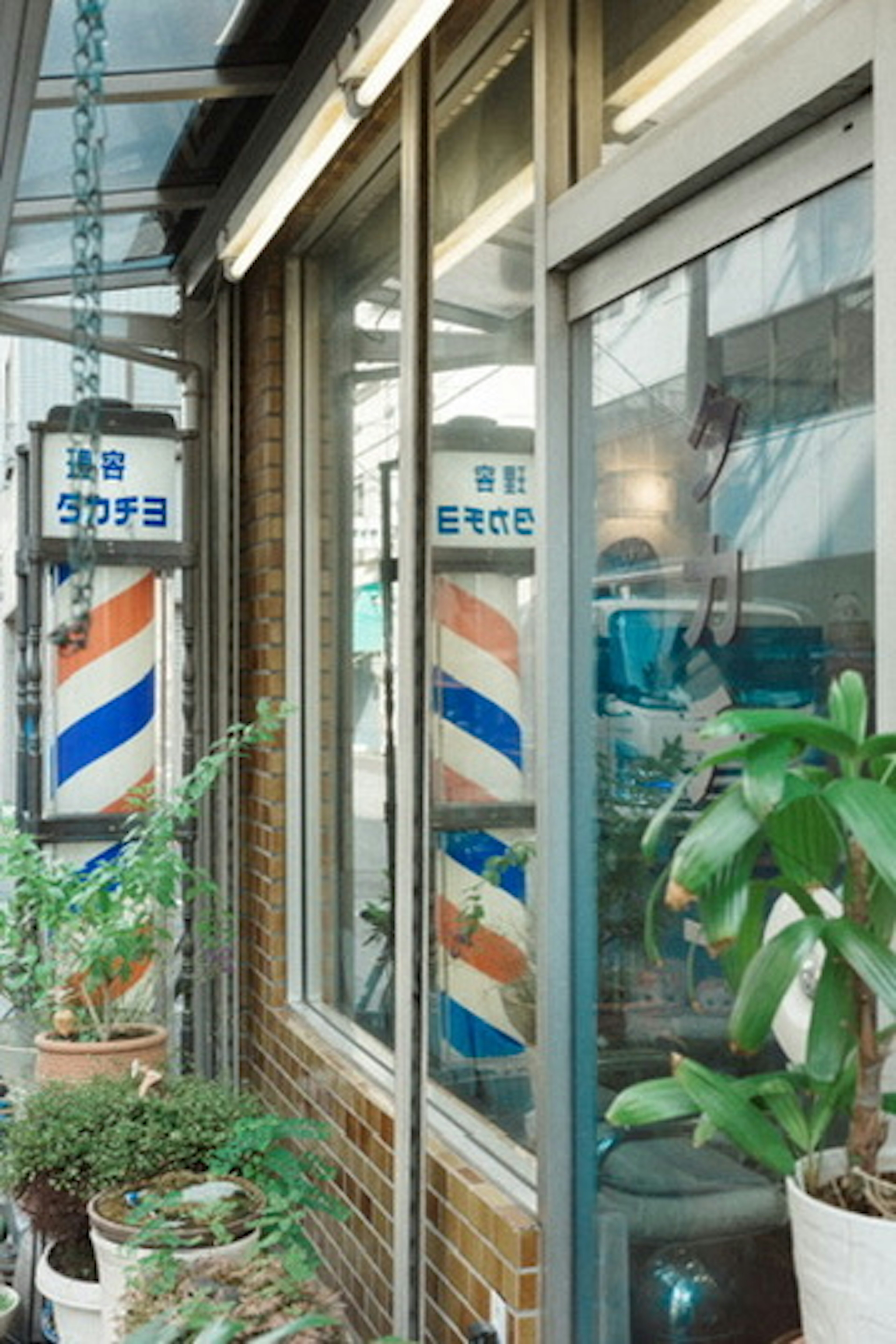 Exterior de una barbería con rayas azules y naranjas