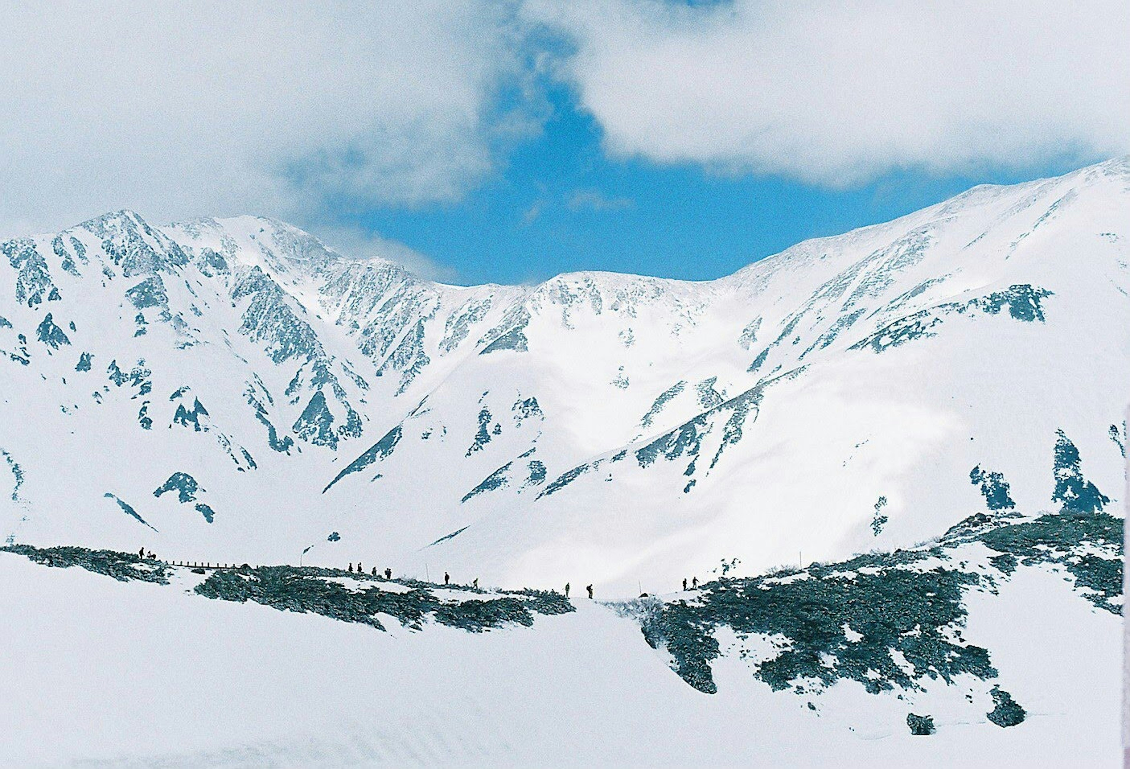 Snow-covered mountains under a blue sky