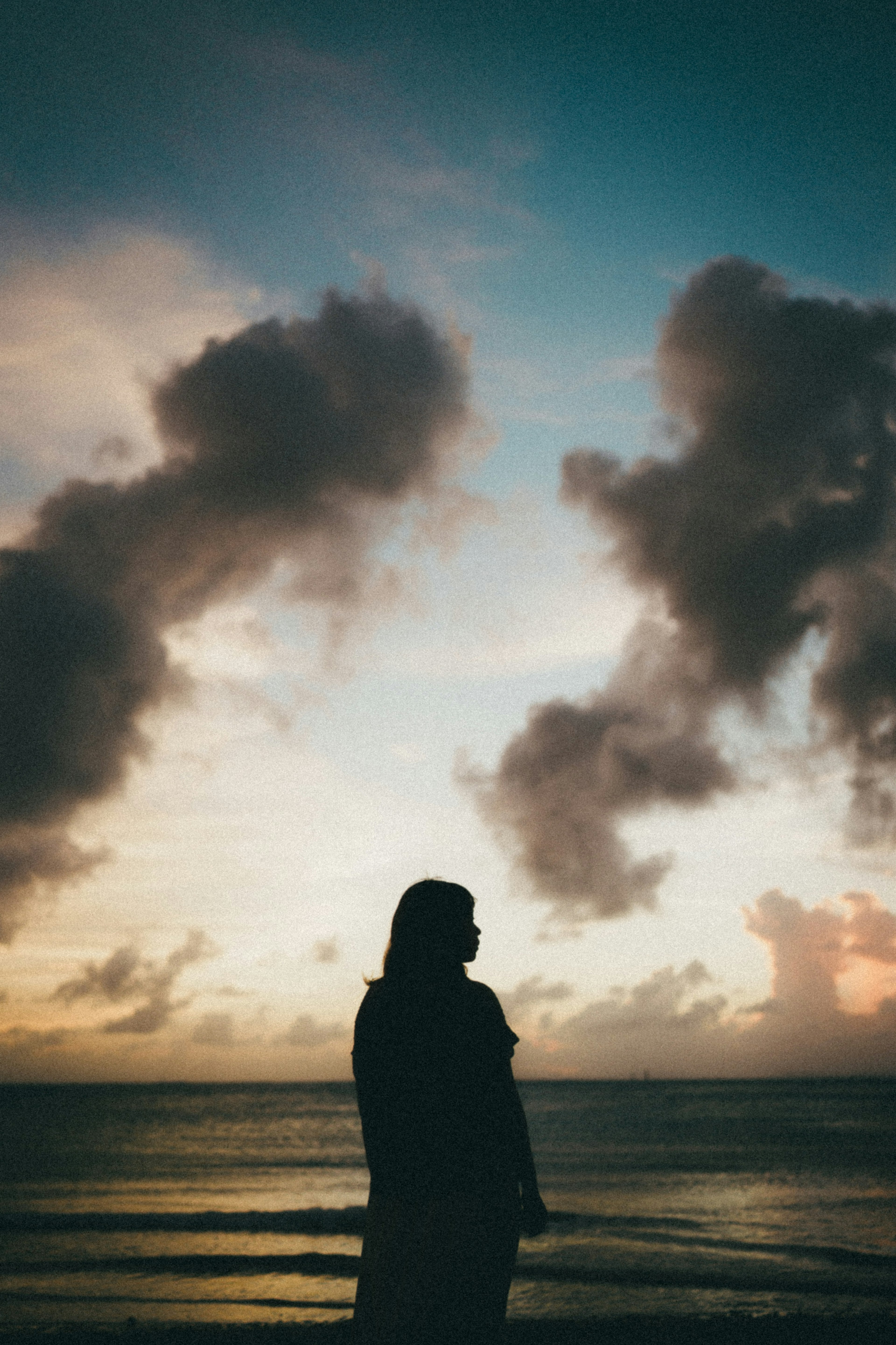 Silhouette au bord de la mer avec des nuages au coucher du soleil