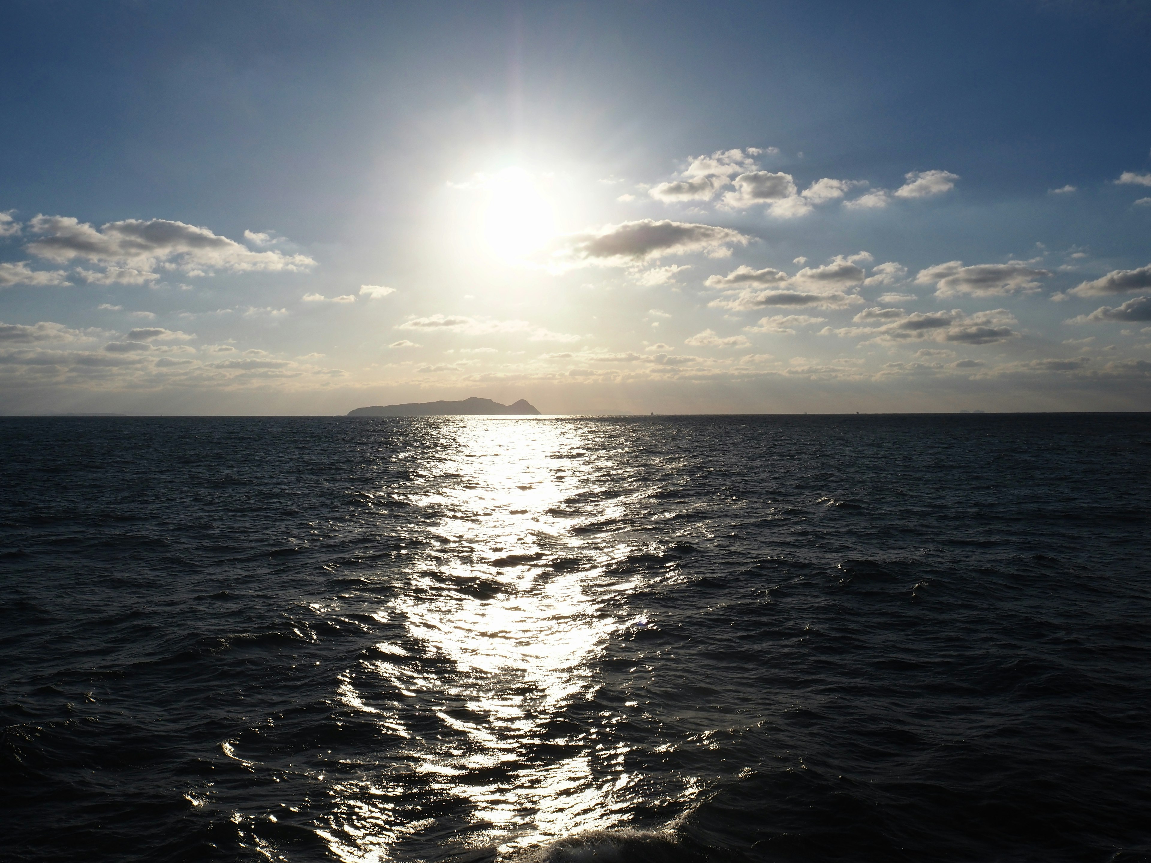 Sun shining over the ocean with reflections