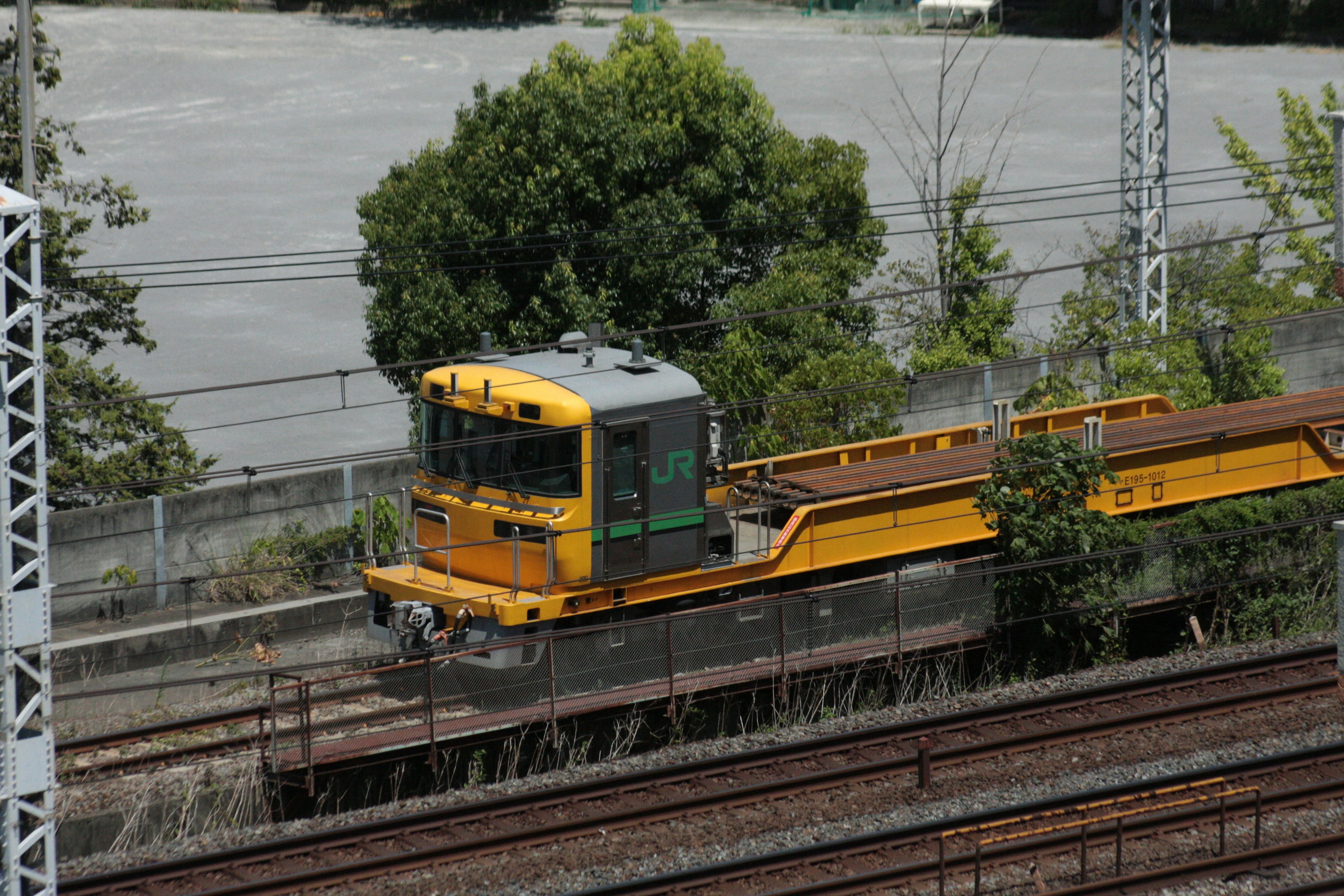 Yellow track maintenance vehicle parked along the railway