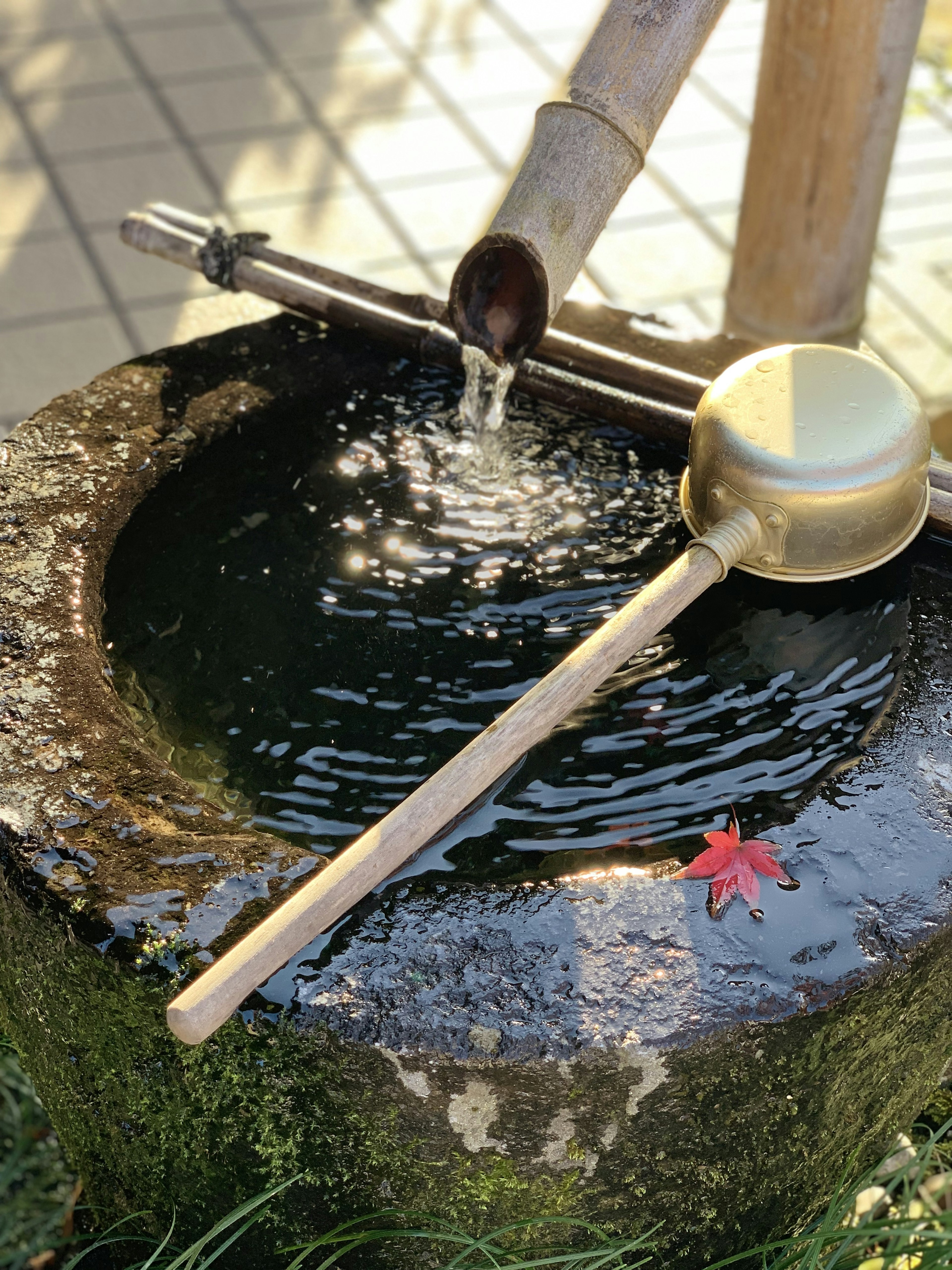 Stone water basin with bamboo water spout and ladle