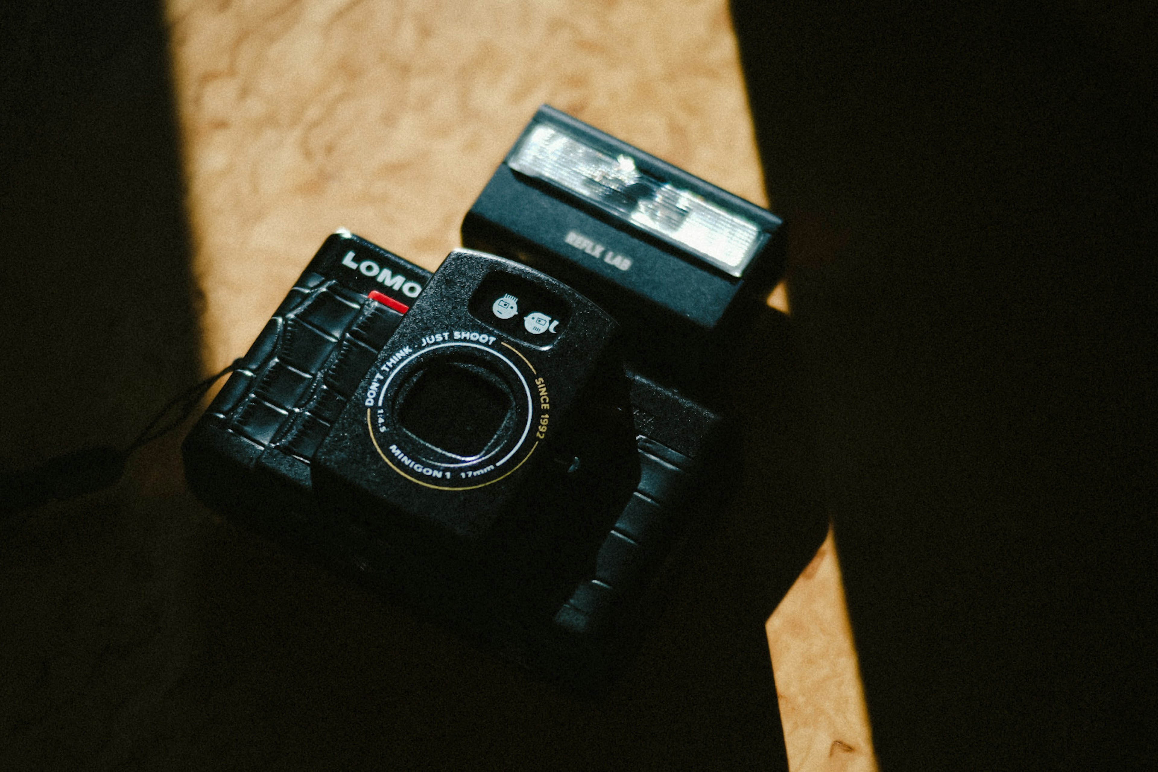 Black Lomography camera with flash placed in a dark setting