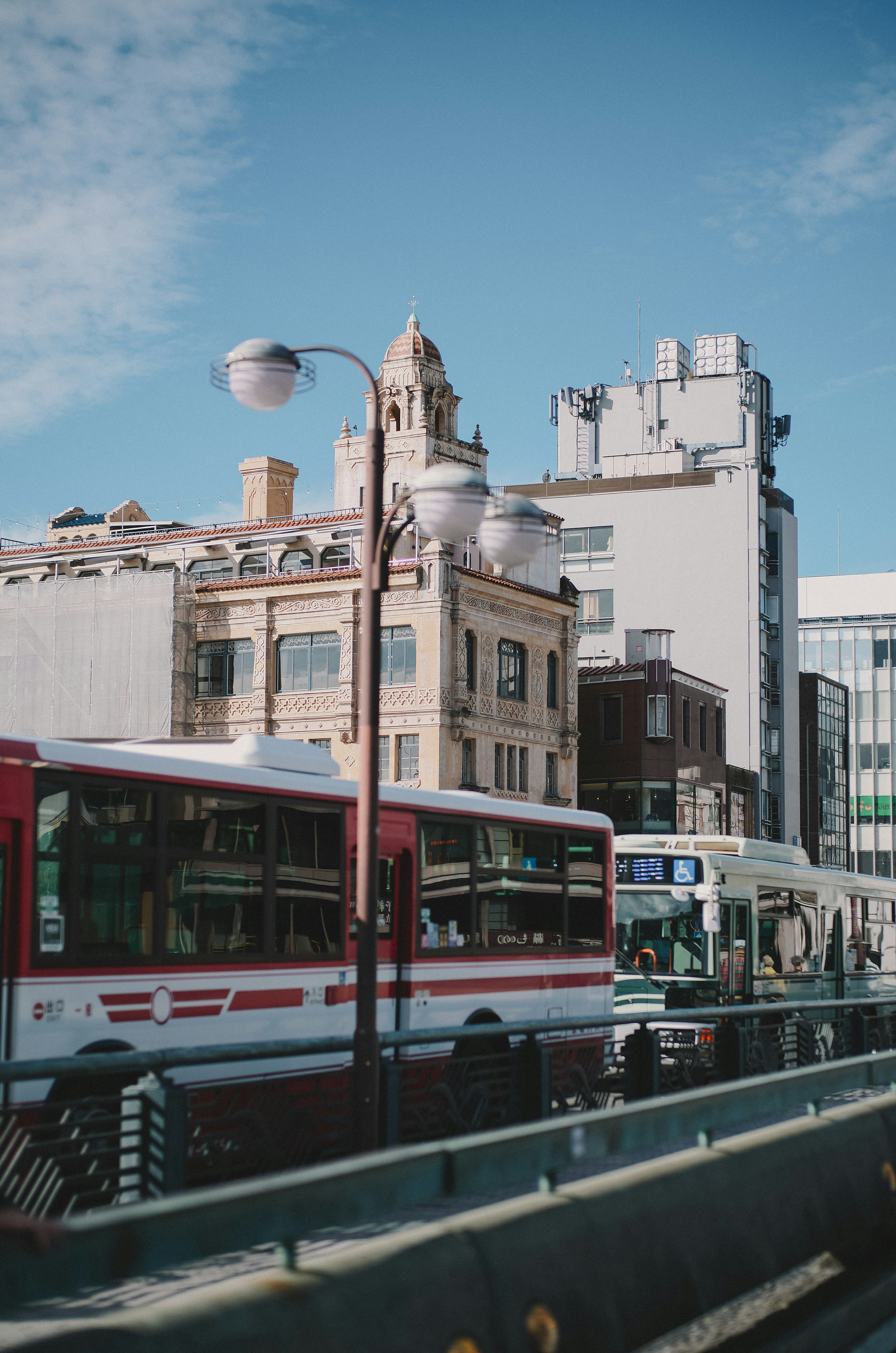 Scena di città con autobus rossi e bianchi sulla strada