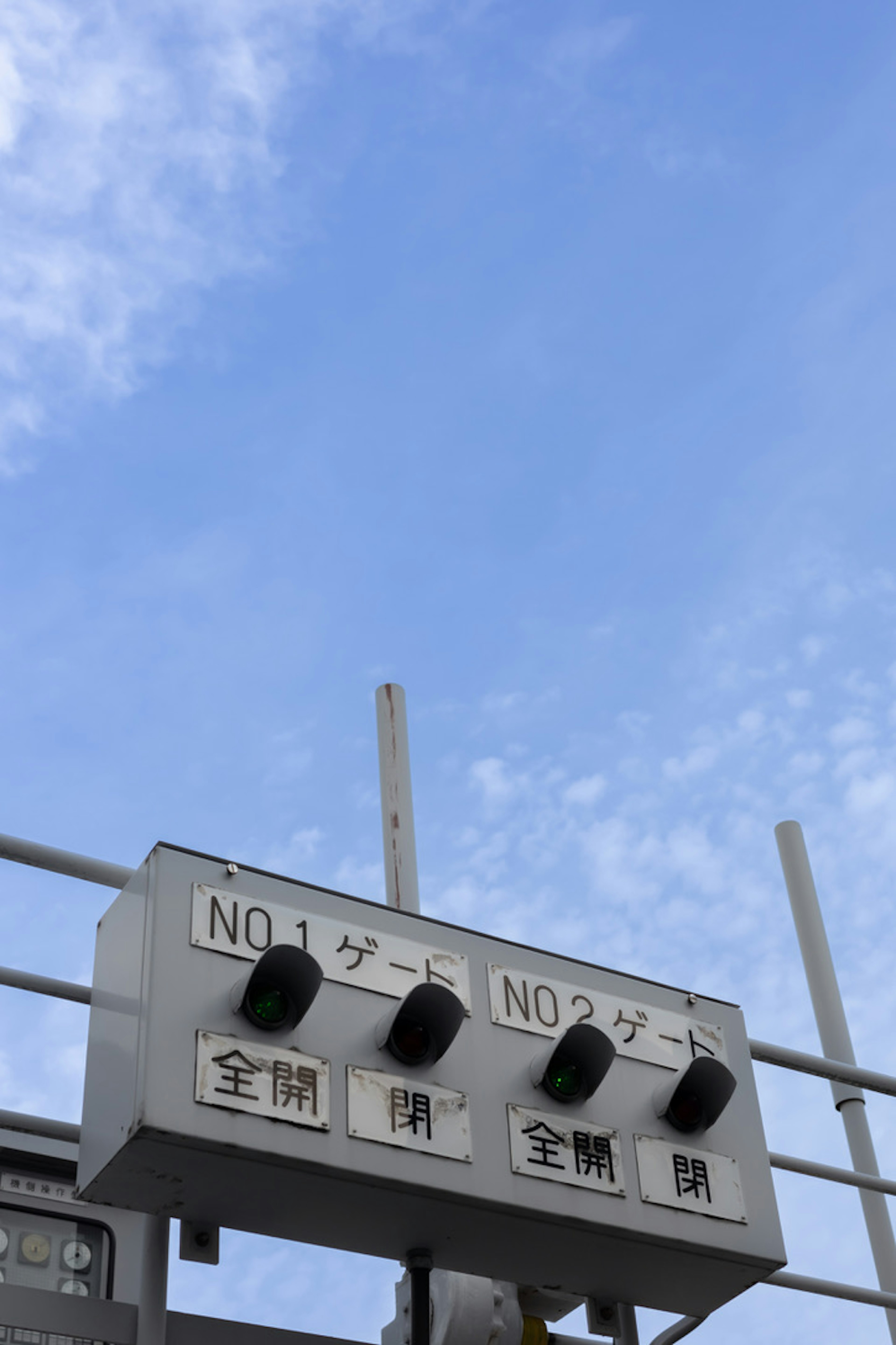 Control panel for two gates under a blue sky