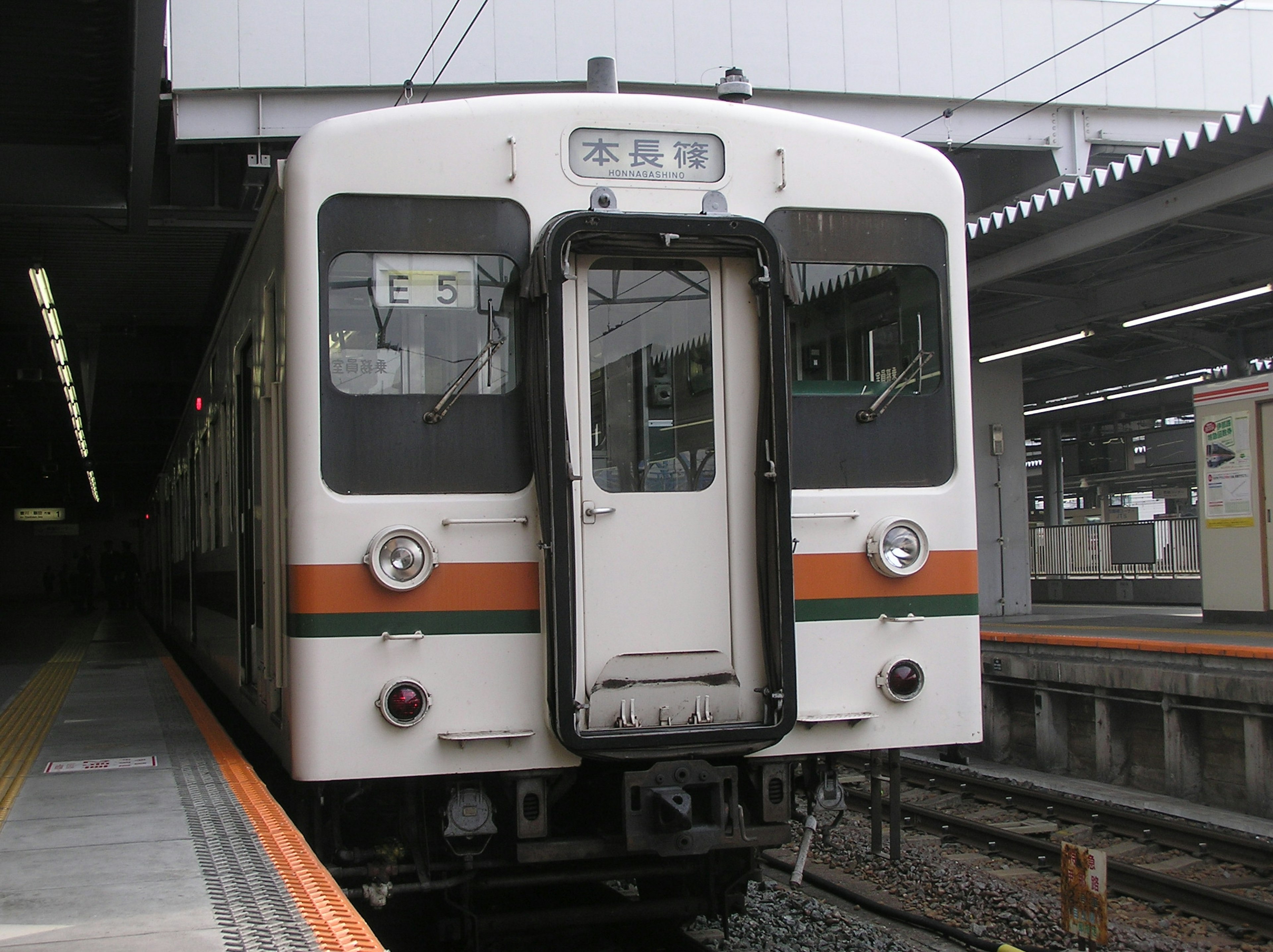 白い電車が駅に停車中でドアが開いている