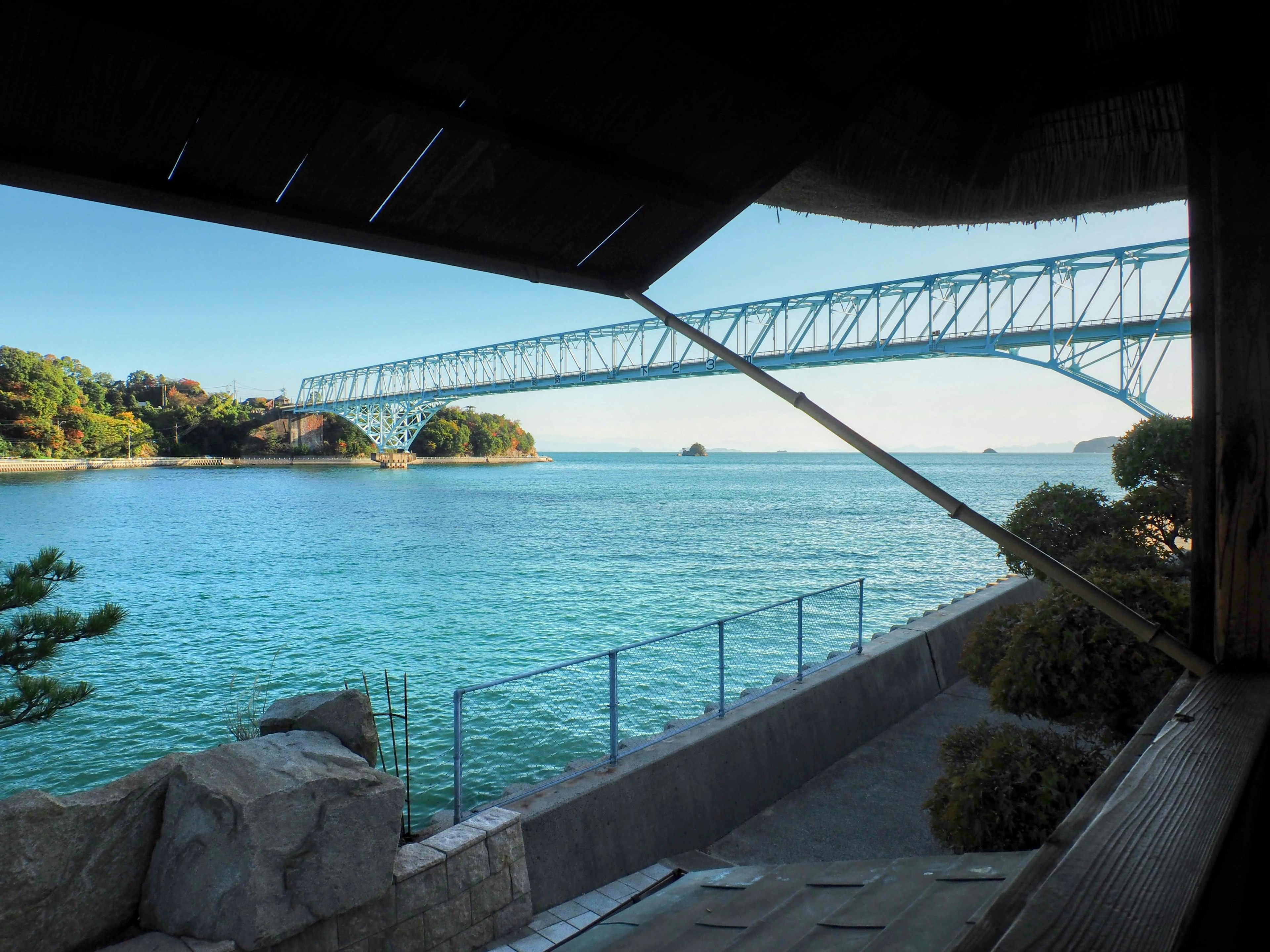 Scenic view of ocean and bridge with surrounding greenery