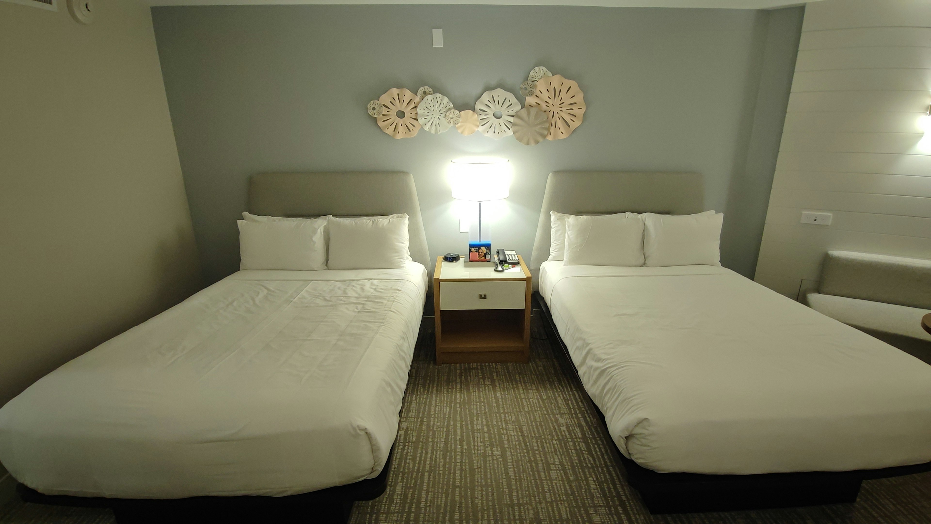 Modern hotel room featuring two single beds and a nightstand