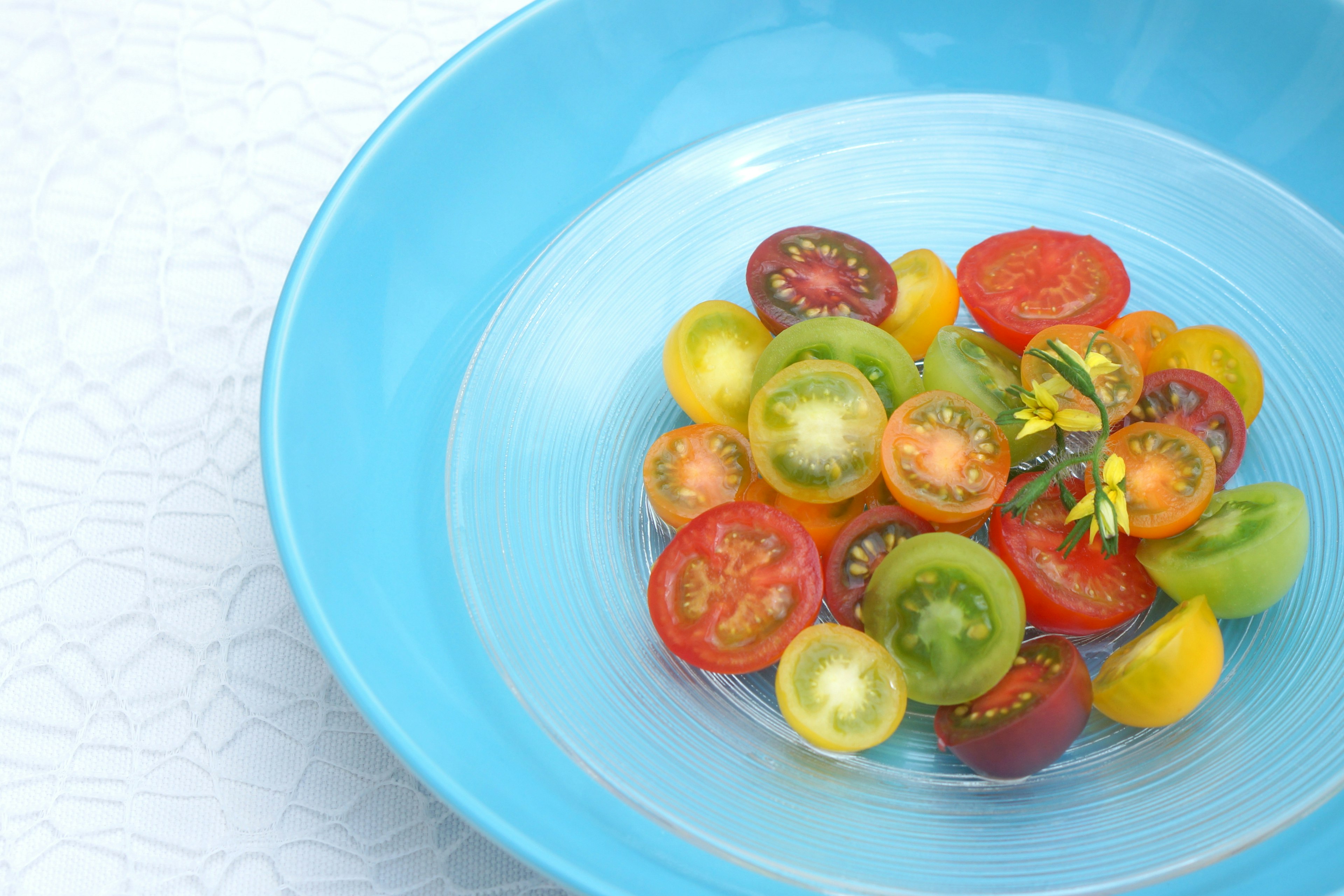 Bunte Kirschtomaten auf einem blauen Teller angeordnet