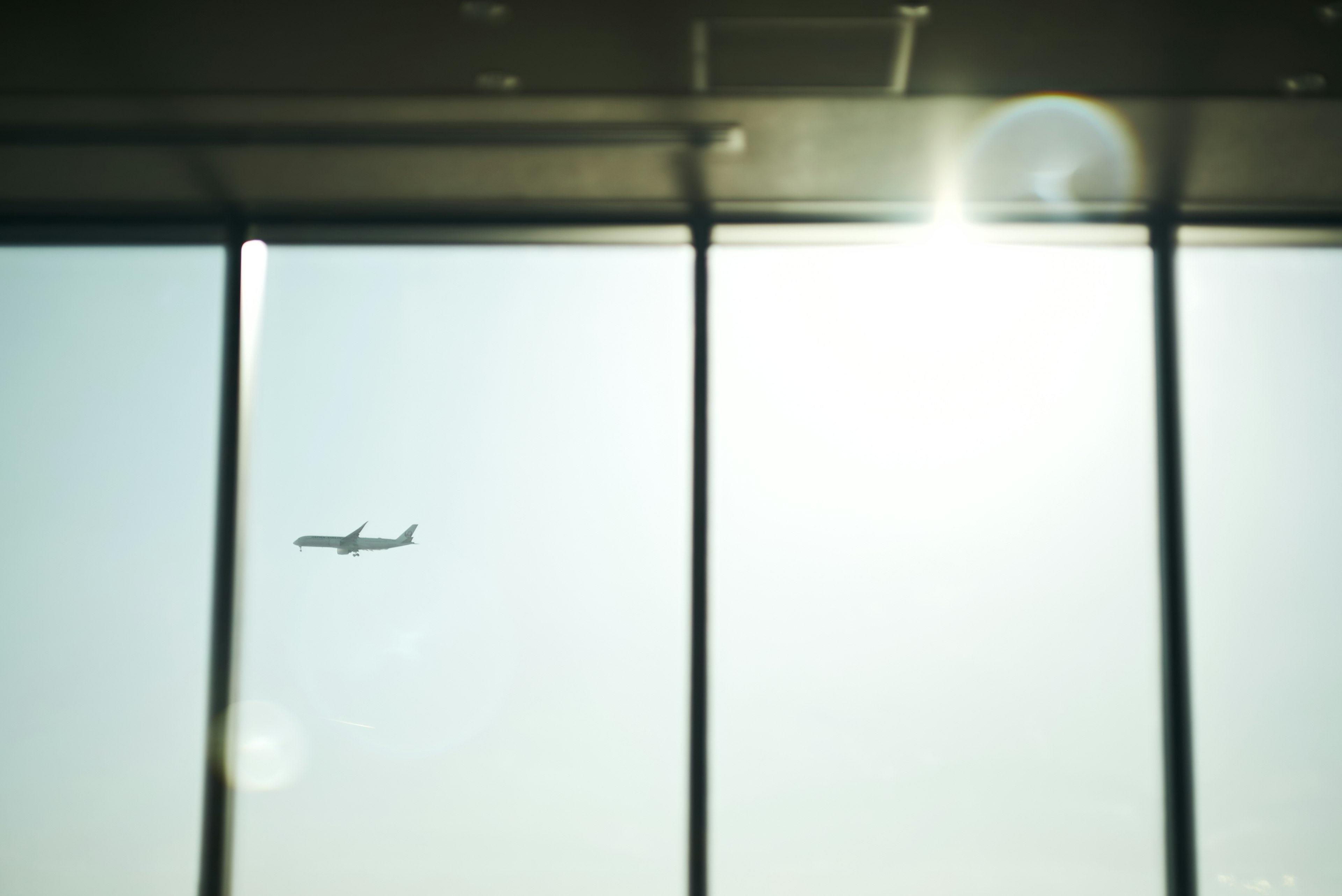 Airplane seen through airport window with sunlight