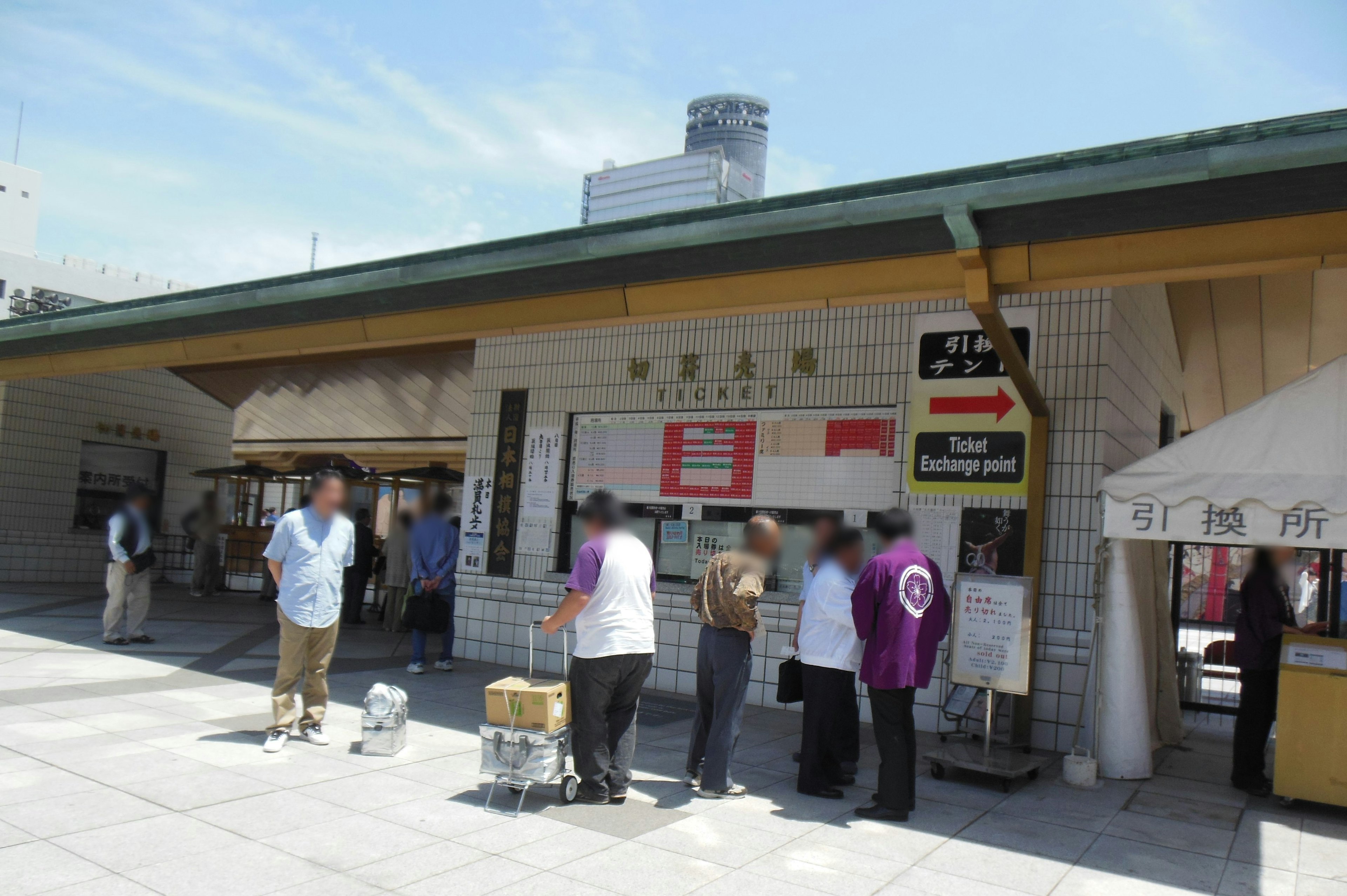 駅の外観と並ぶ人々