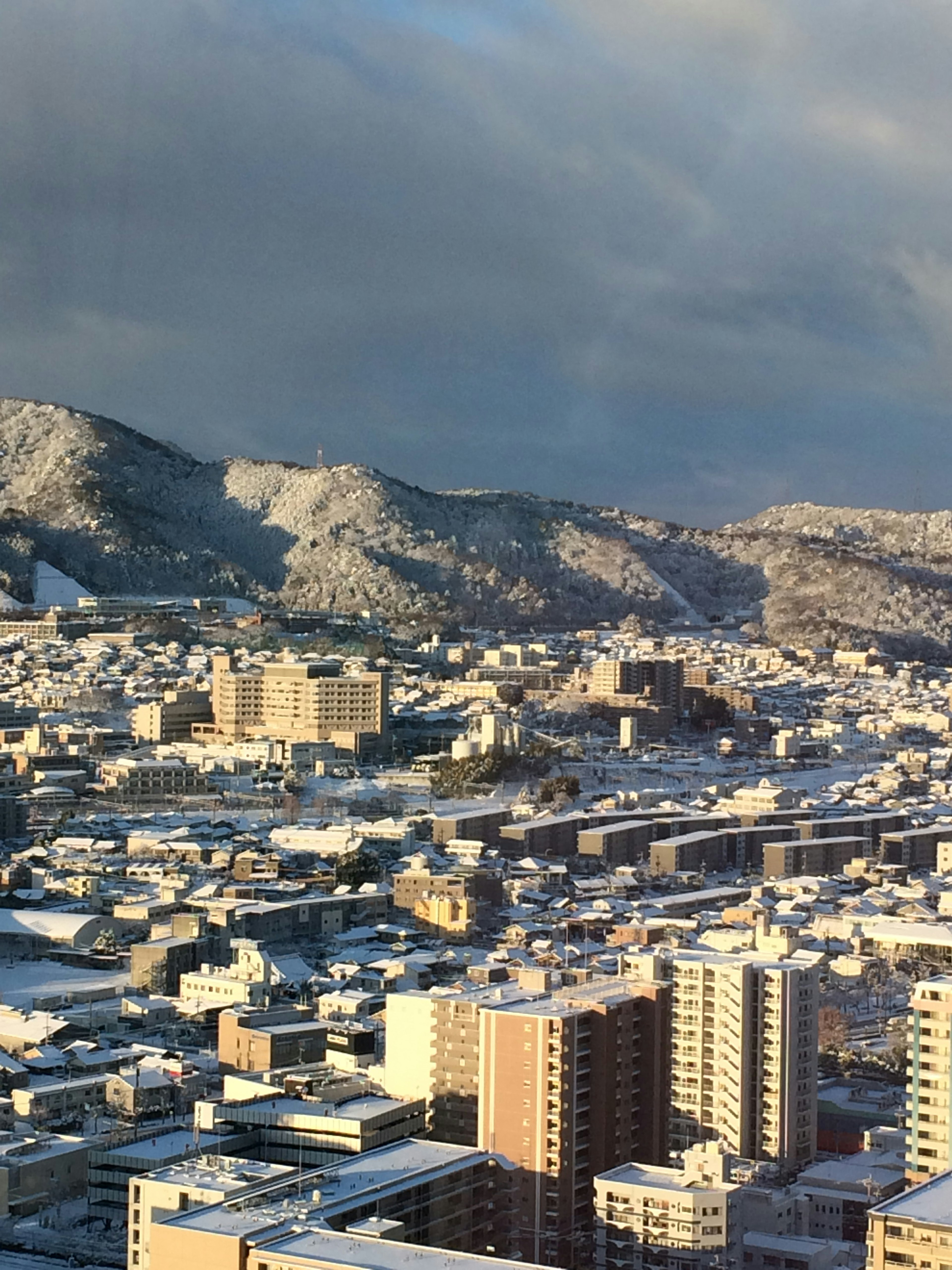 Snow-covered cityscape with mountains in the background