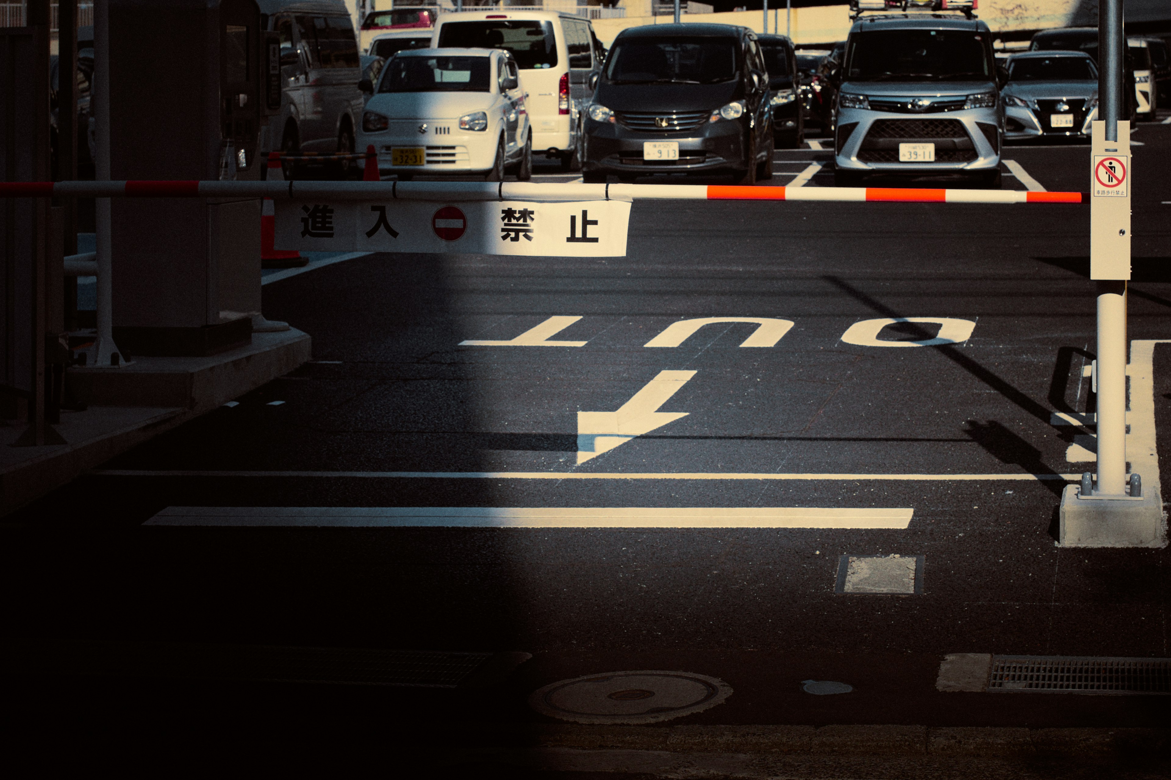 Scène de parking avec une barrière et un panneau de signalisation indiquant la sortie