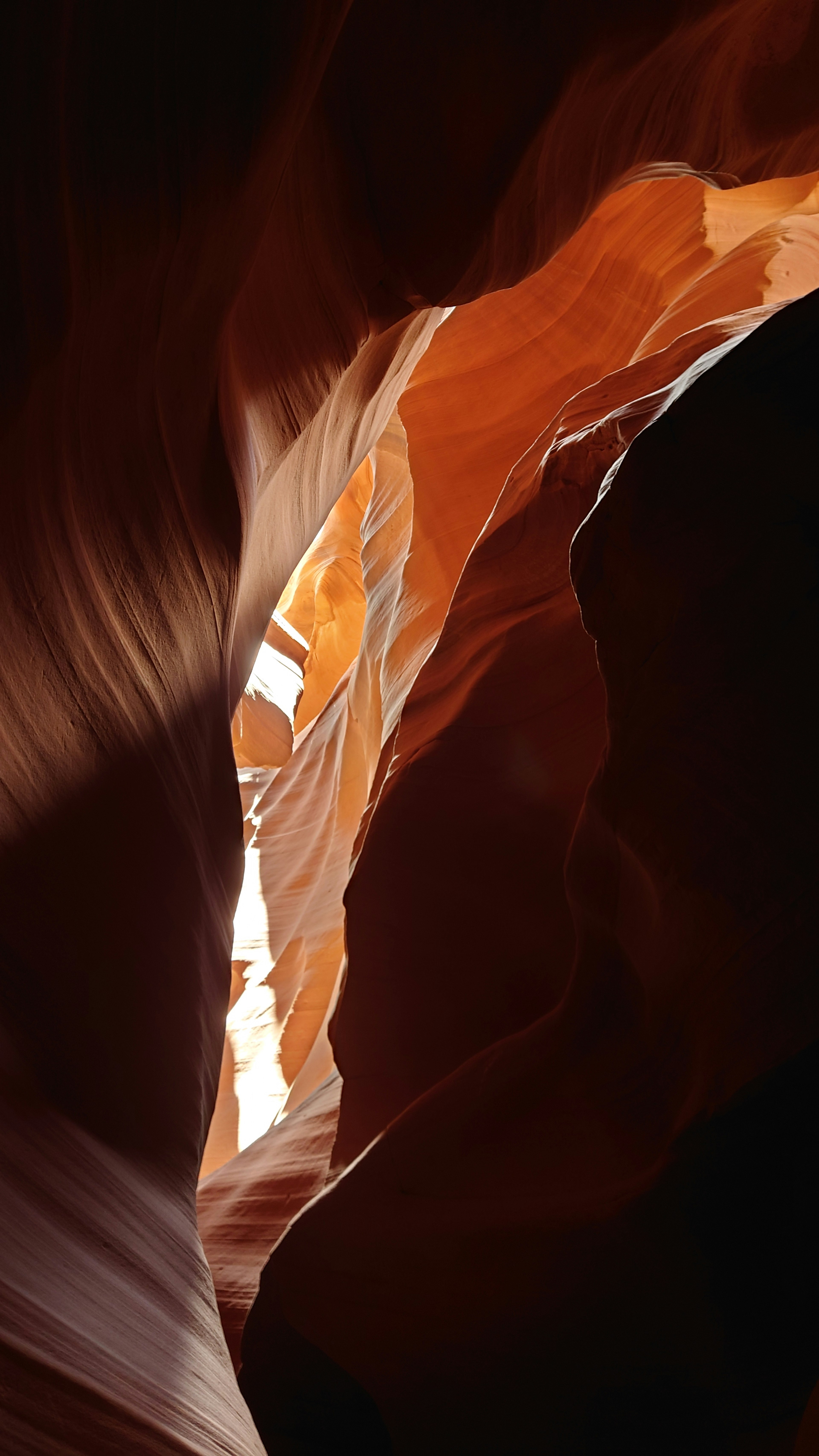 Schönes Bild eines Canyon-Innenraums mit orangefarbenen Tönen und Licht, das durch enge Öffnungen strömt