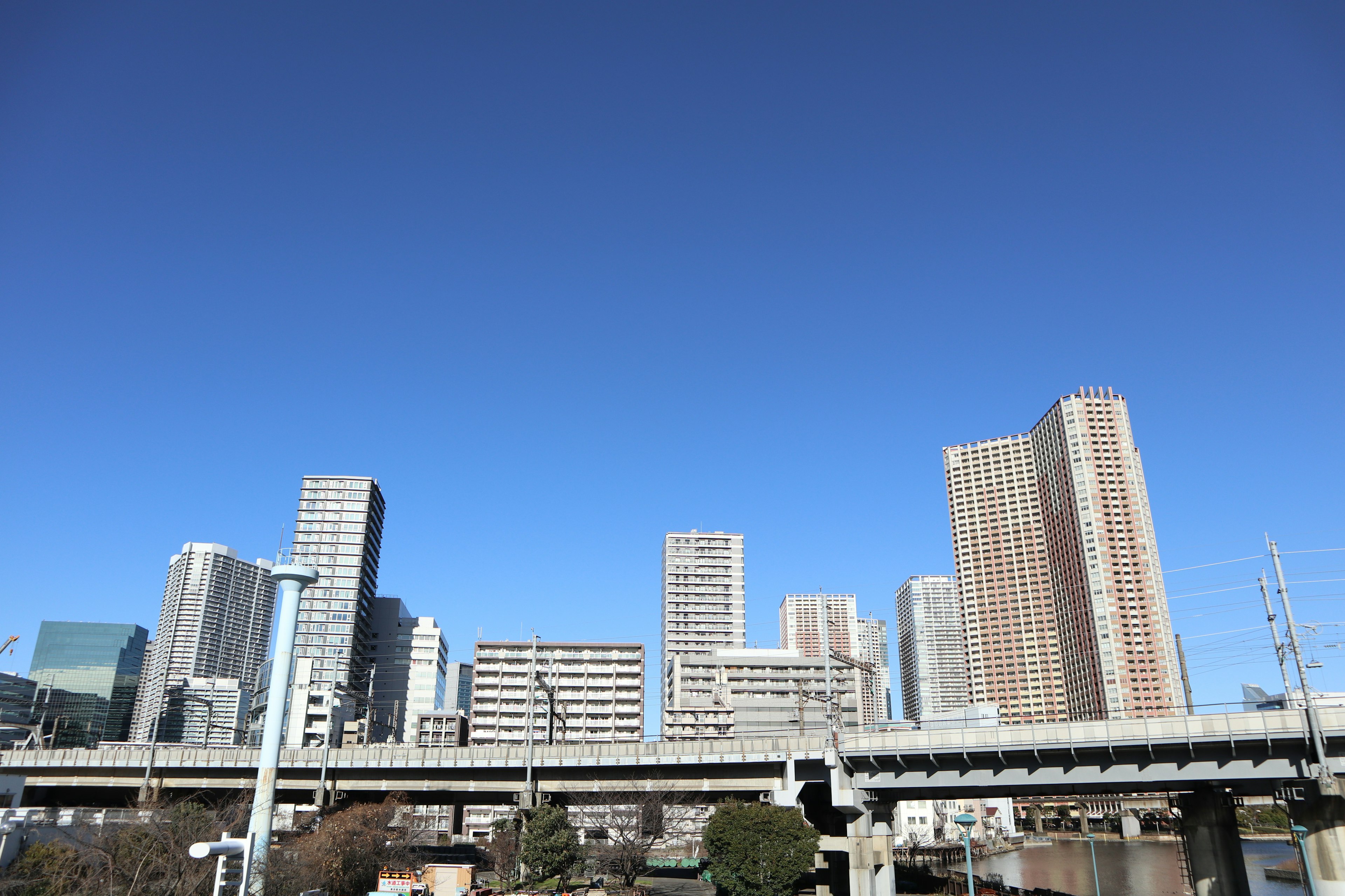 晴れた青空の下に高層ビルが立ち並ぶ都市の風景