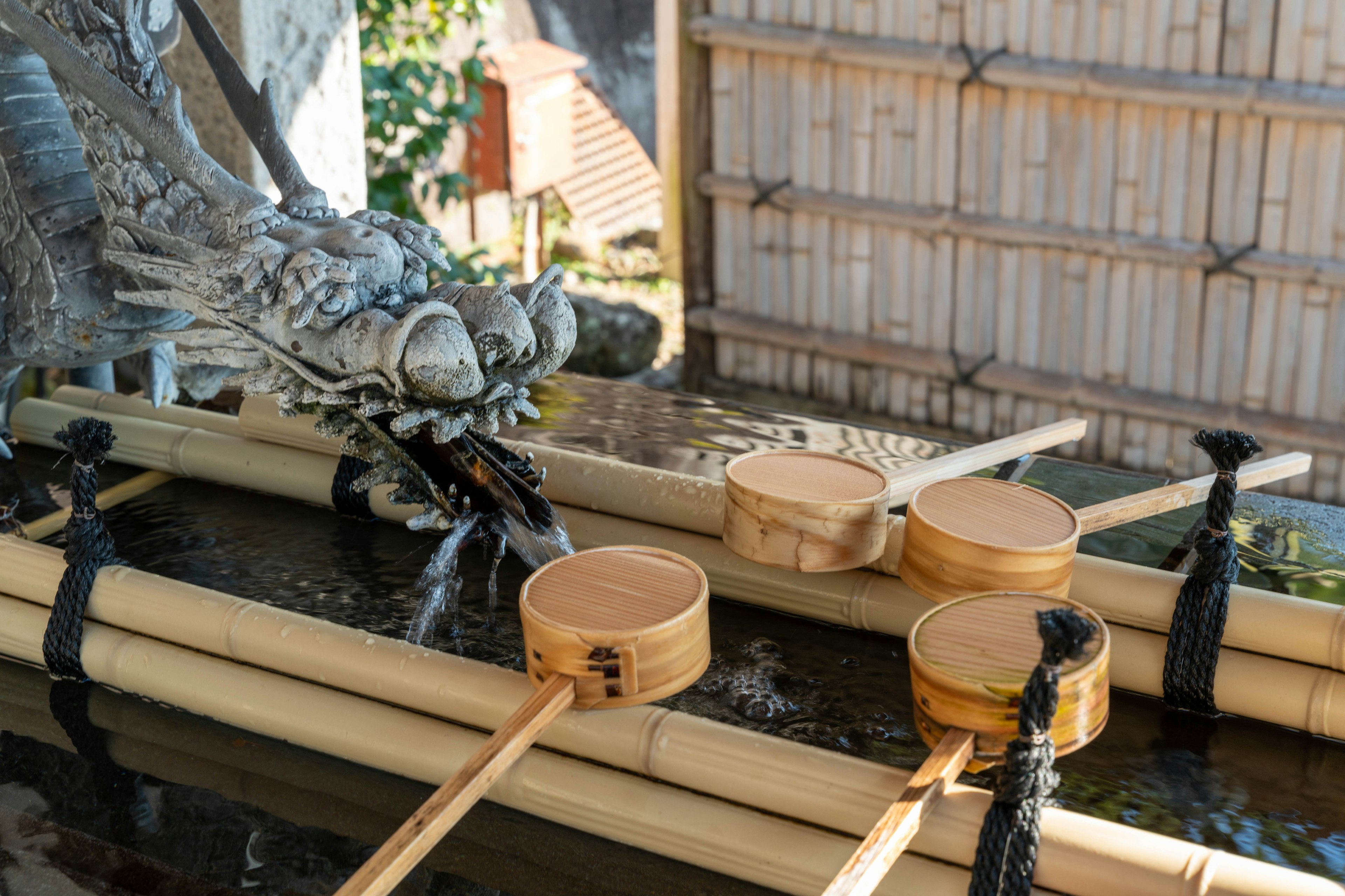 Bañera de agua de bambú con escultura de dragón y cucharas de madera